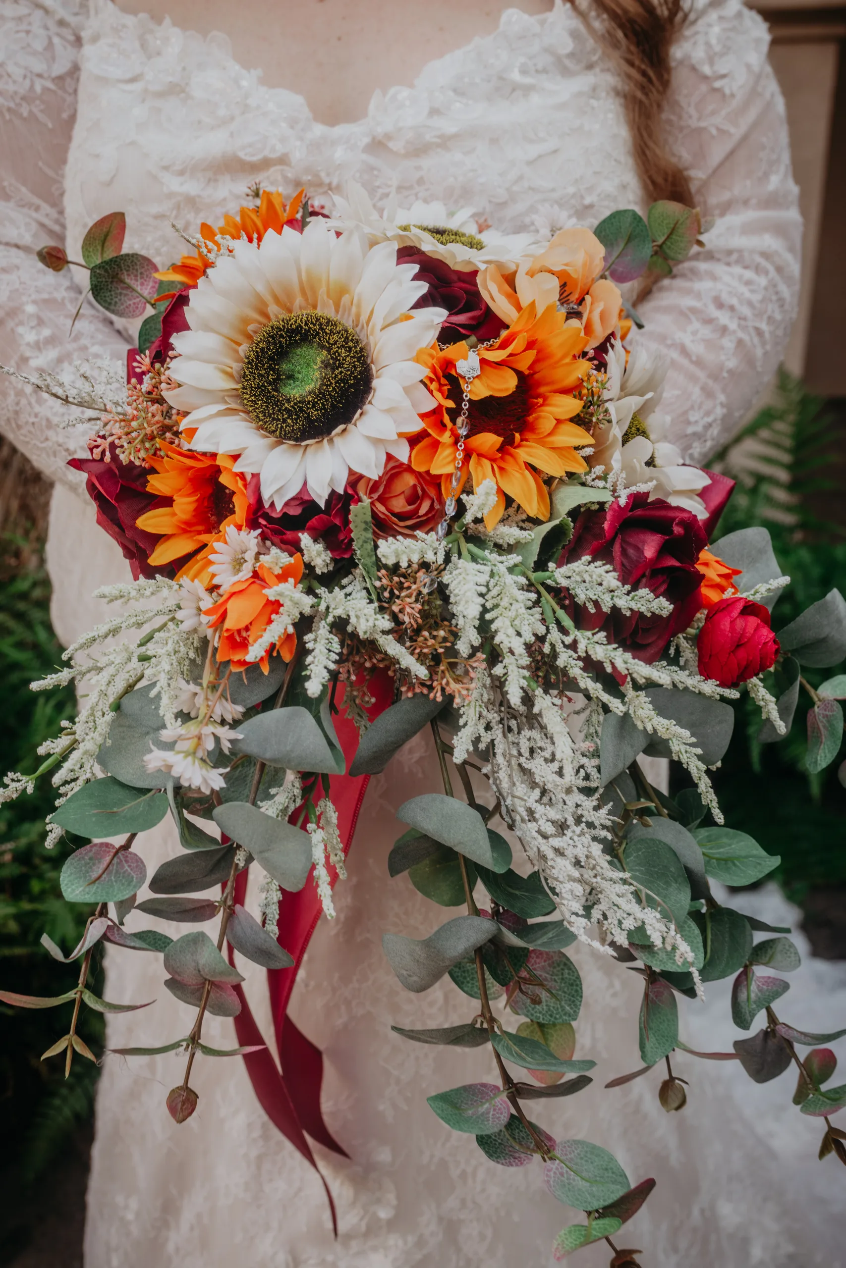 Wedding Florals: her bouquet of sunflowers, burgundy roses and eucalyptus, at their wedding at St. Lawrence Catholic Church in Lawrenceville, GA