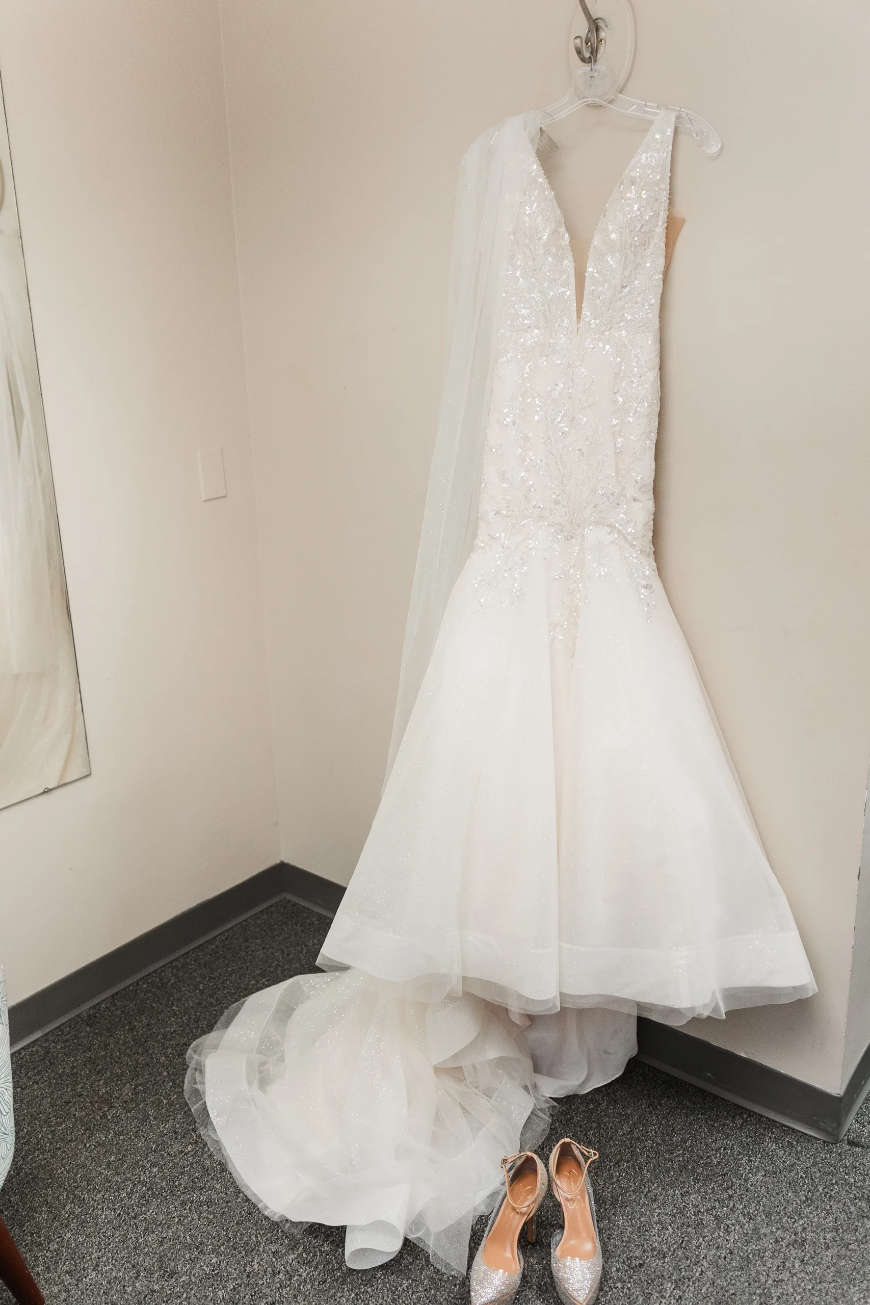 Wedding Details: her beaded mermaid gown and veil hanging in the bridal suite, her heels below, at a wedding at the Historic DeKalb Courthouse in Decatur, GA