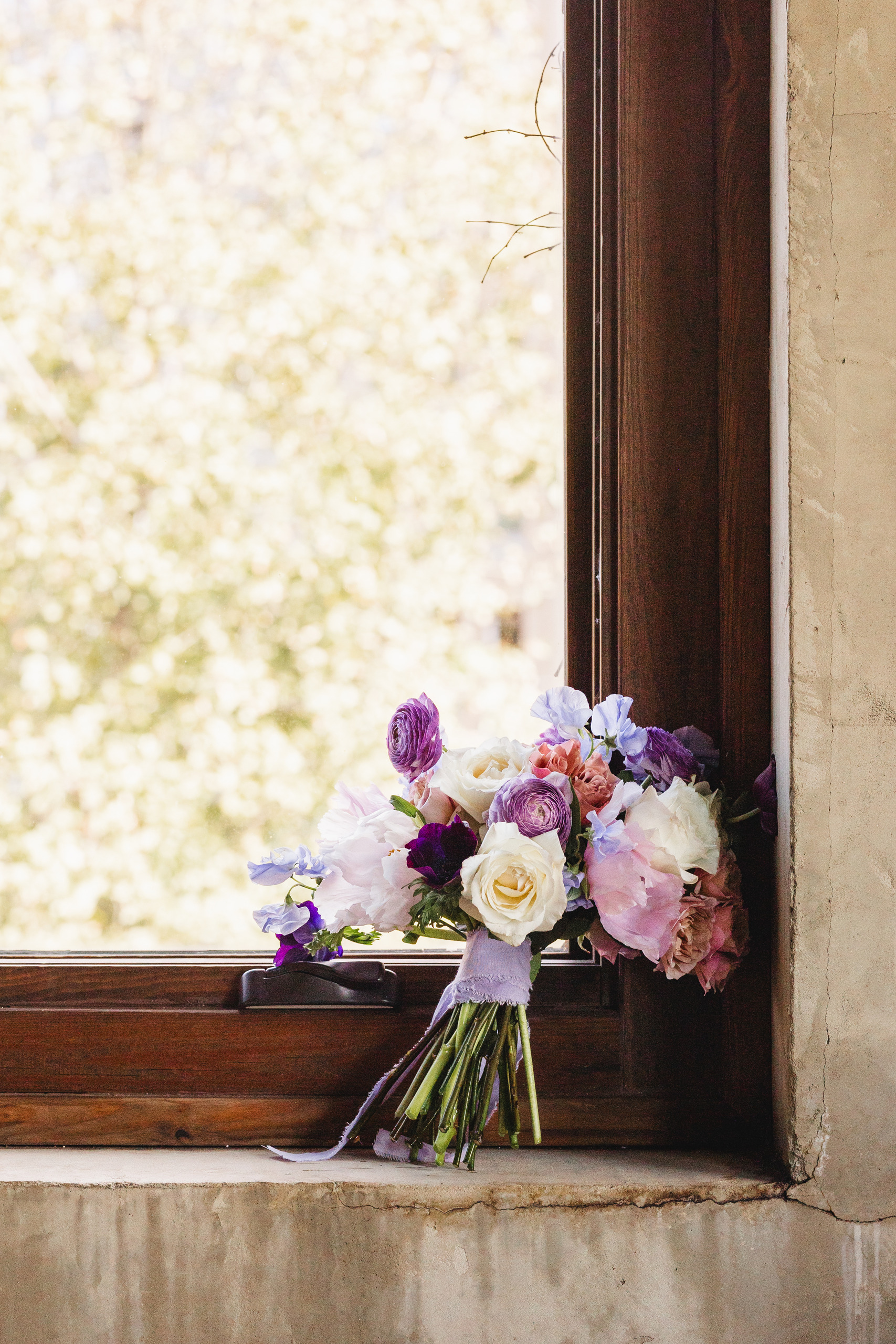 Wedding Florals: her bouquet resting in the window light, before their wedding at Summerour Studio in Atlanta, GA