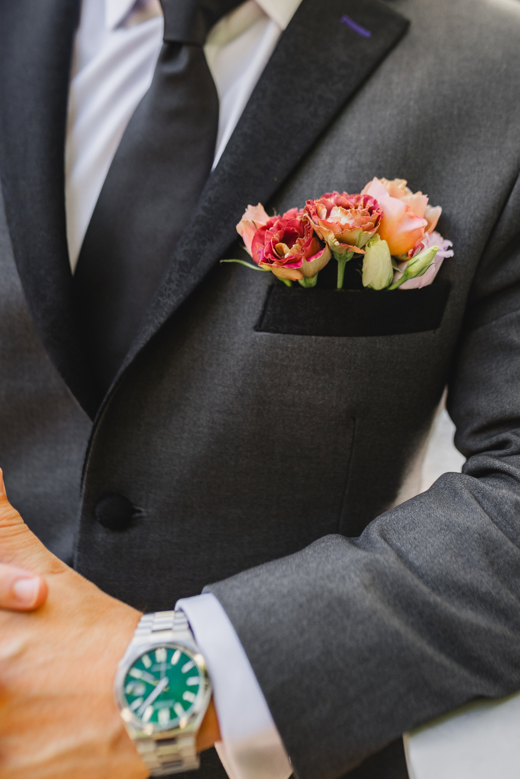 Wedding Details: his pocket square of coral and peach roses above his watch, before their wedding at Summerour Studio in Atlanta, GA