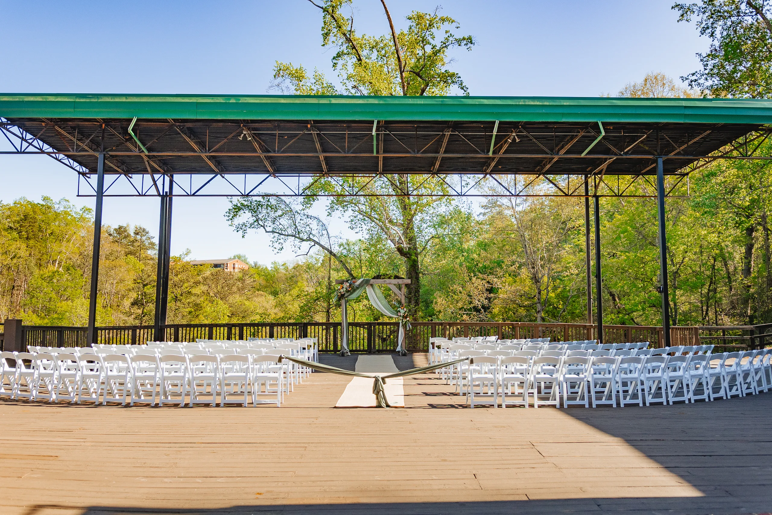 Wedding Ceremony: the deck set with white chairs overlooking Vickery Creek at a wedding at Ivy Hall at Roswell Mill in Roswell, GA