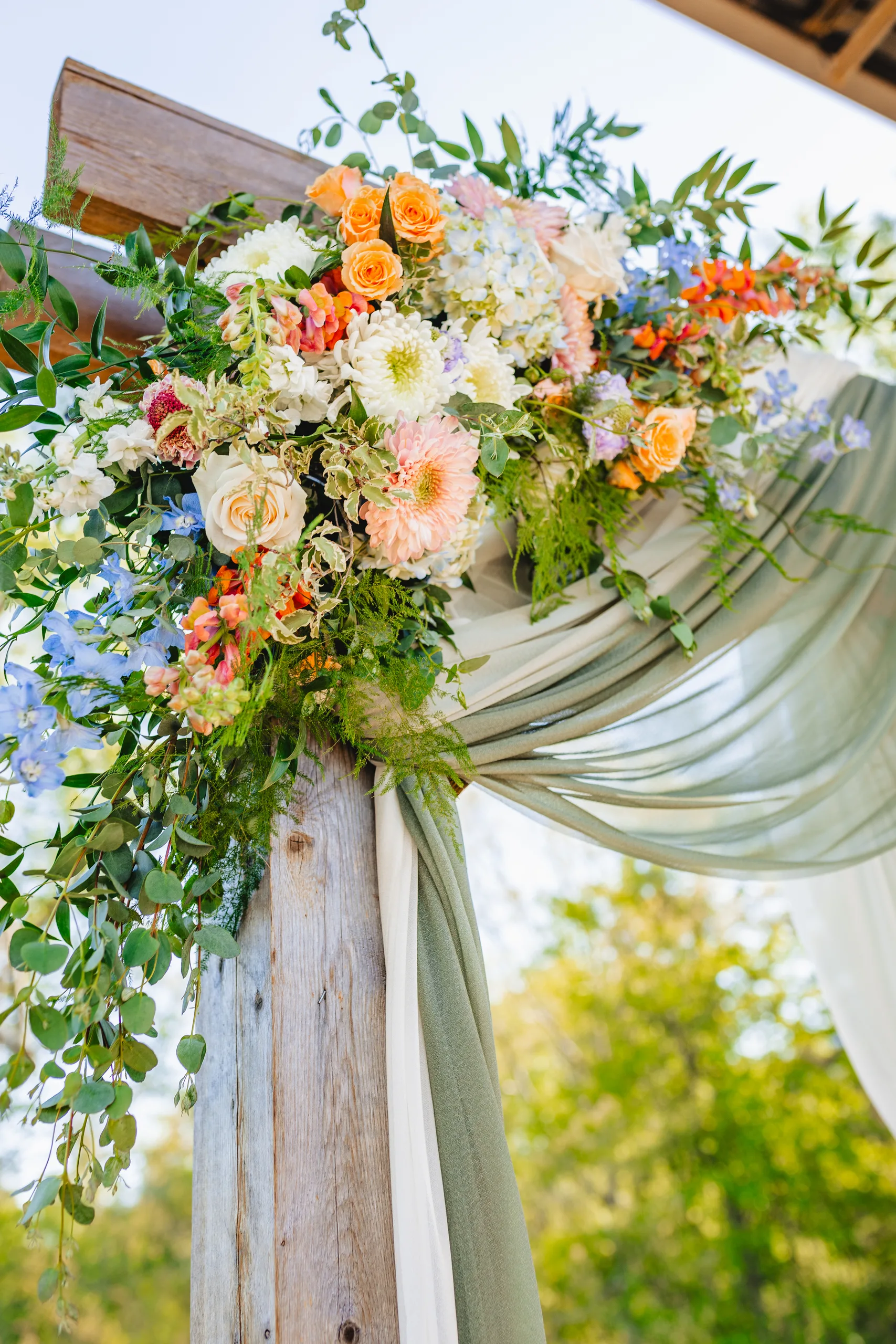 Wedding Florals: peach and blue flowers on the ceremony arch at a wedding at Ivy Hall at Roswell Mill in Roswell, GA