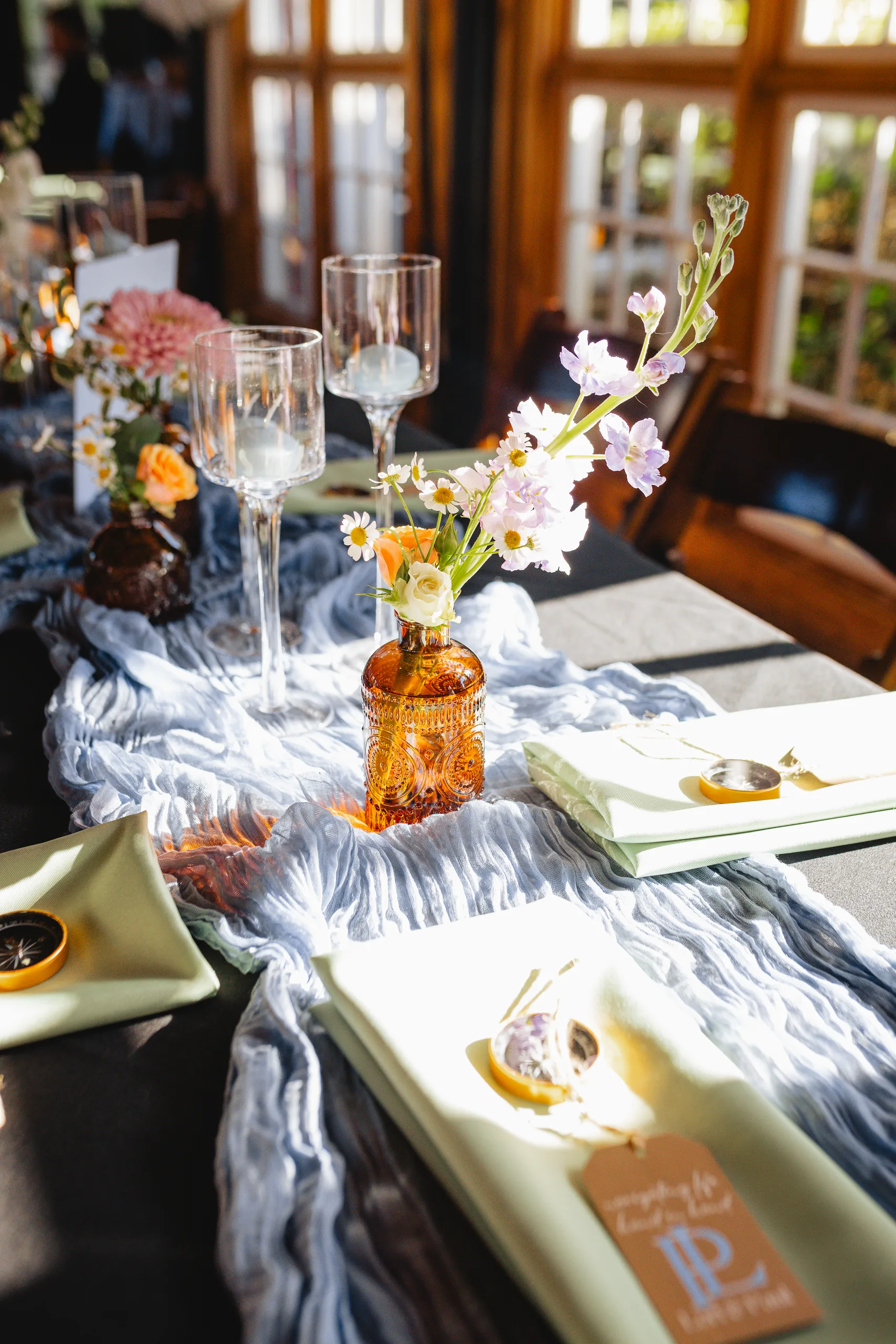 Reception Details: a place setting with a compass favor and tag at a wedding at Ivy Hall at Roswell Mill in Roswell, GA