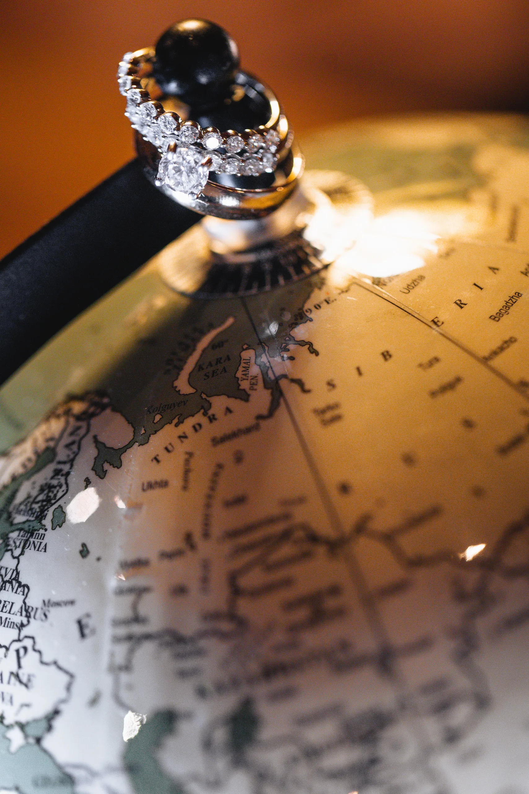 Wedding Details: their rings on top of a globe at a wedding at Ivy Hall at Roswell Mill in Roswell, GA