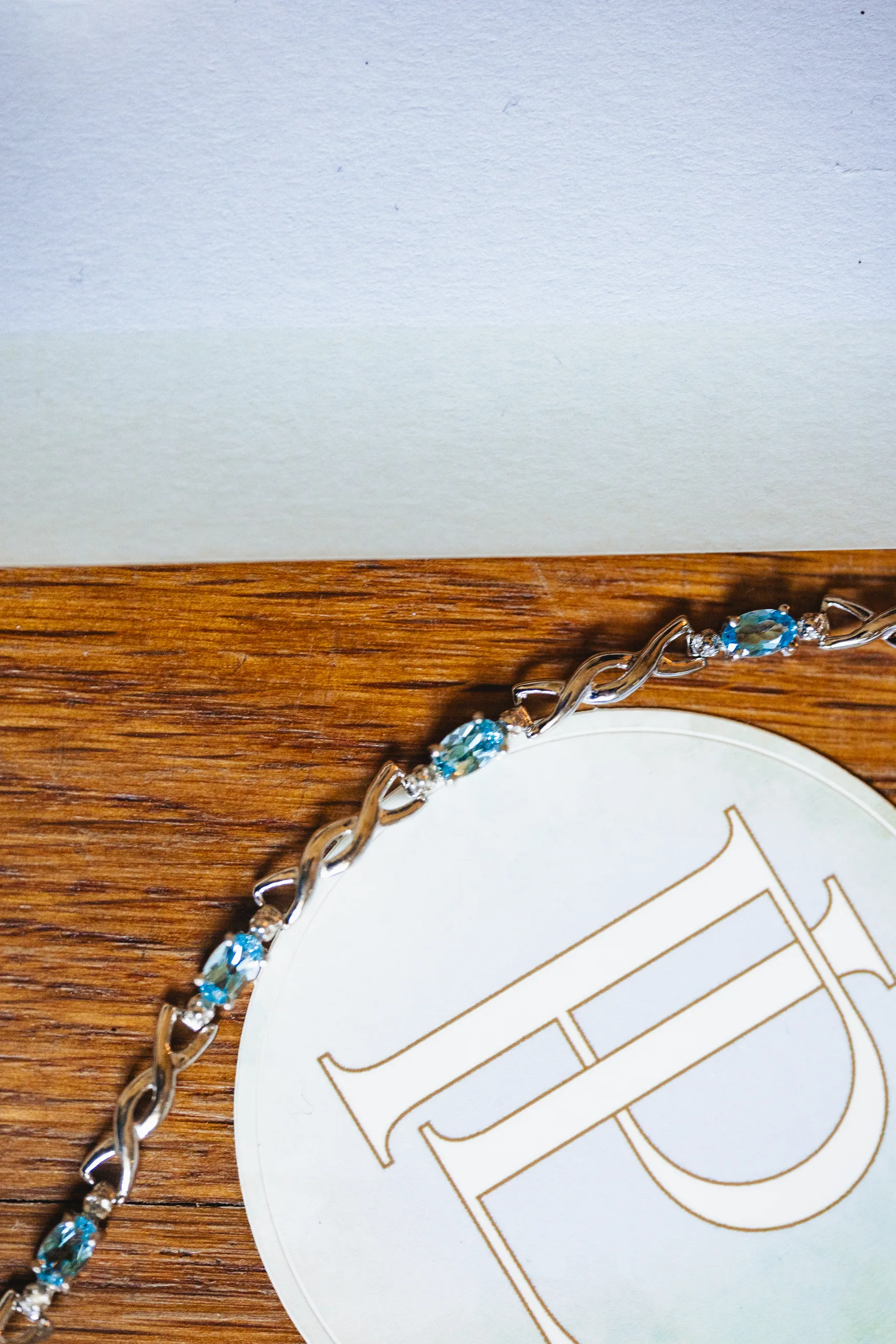 Wedding Details: a blue bracelet across their PL monogram coaster at a wedding at Ivy Hall at Roswell Mill in Roswell, GA