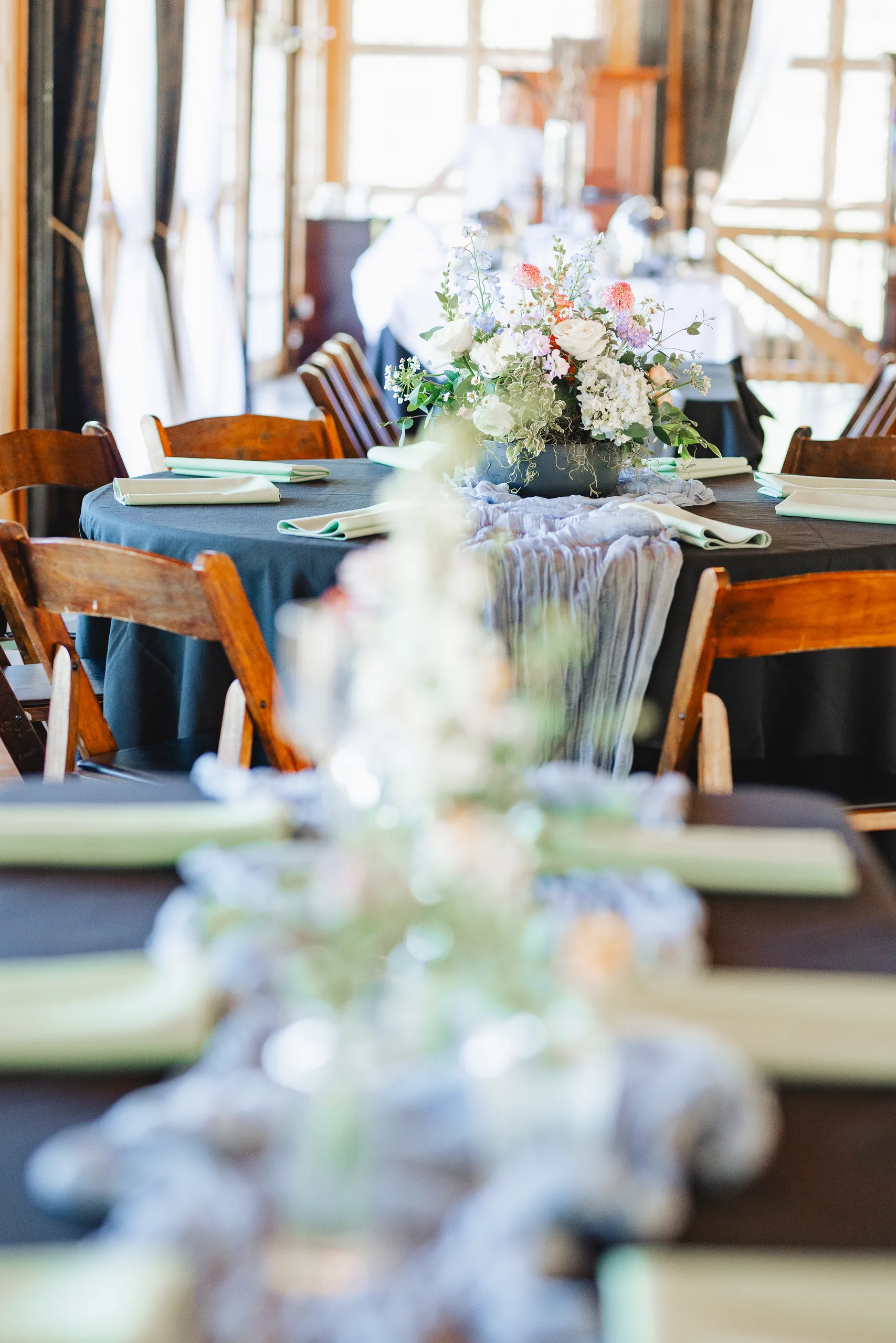 Reception Details: a dusty blue runner and florals down the tables at a wedding at Ivy Hall at Roswell Mill in Roswell, GA