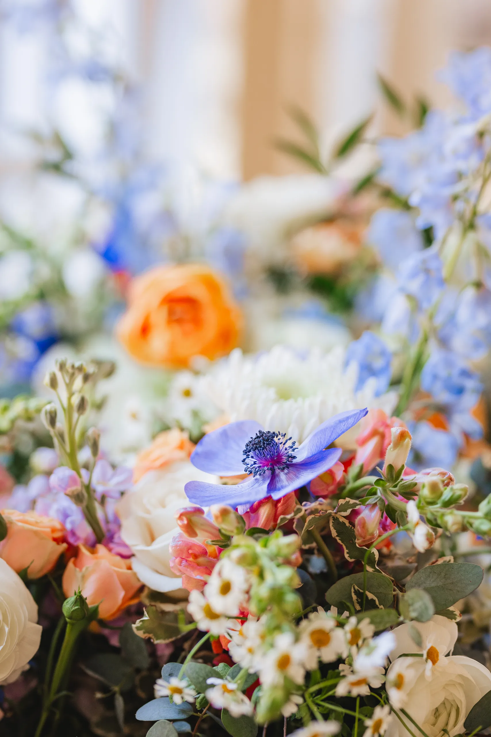 Wedding Florals: blue anemones, peach roses and daisies up close at a wedding at Ivy Hall at Roswell Mill in Roswell, GA