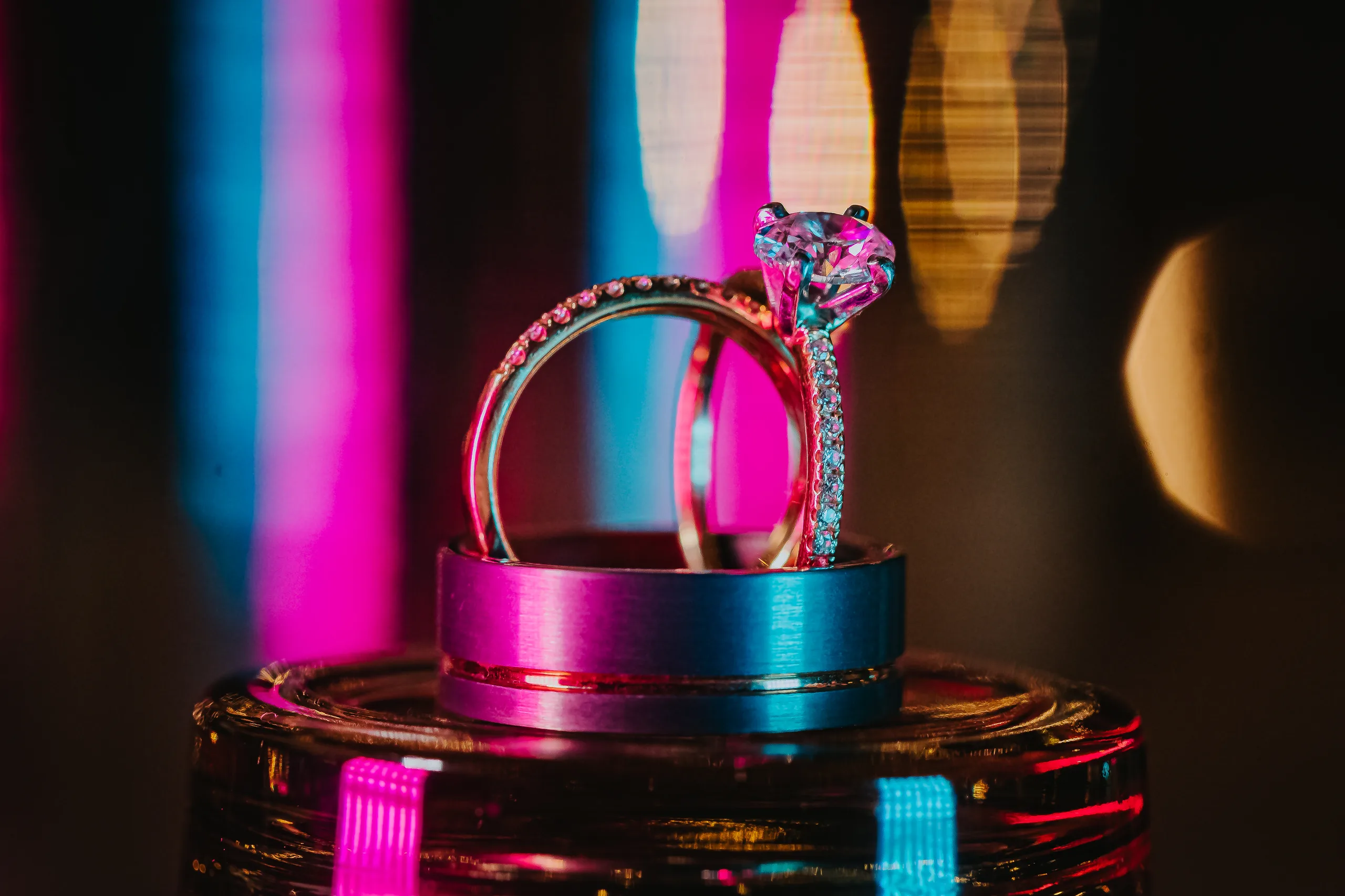 Wedding Details: their rings under pink and blue lights, at a wedding at Terminus 330 in Atlanta, GA