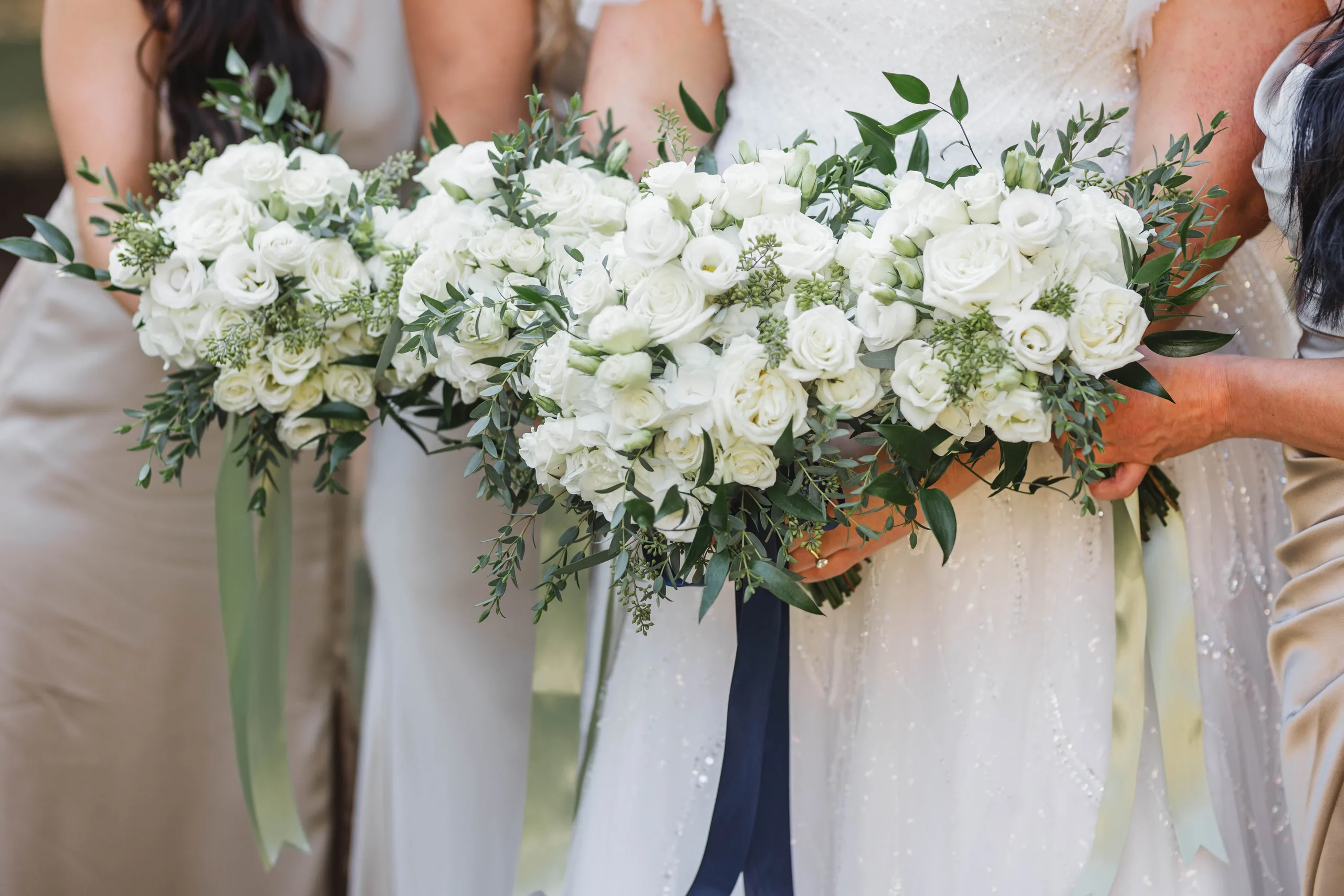 Wedding Florals: the white rose bouquets of the bride and her bridesmaids, her navy ribbon, at their wedding at Naylor Hall in Roswell, GA