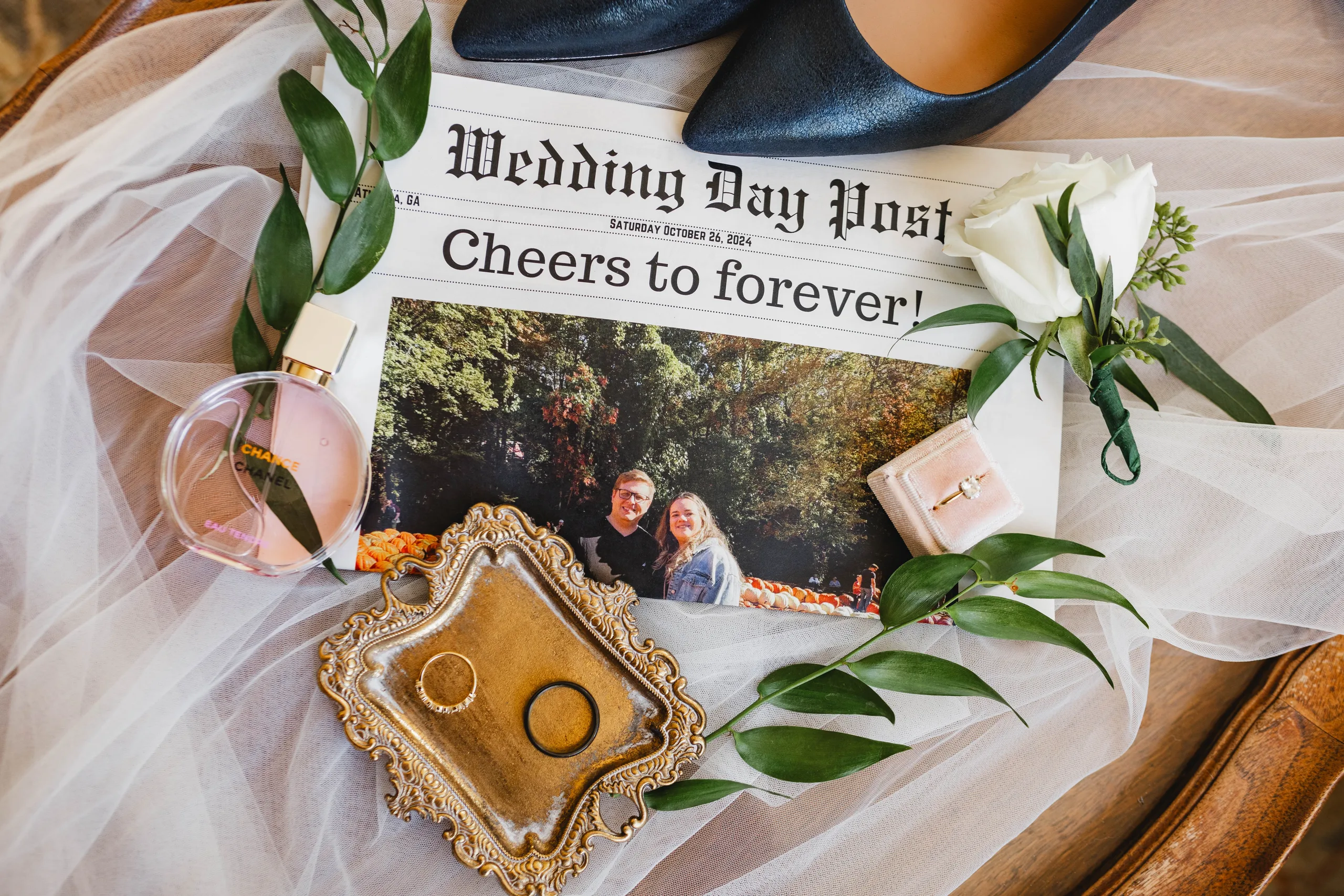 Wedding Details: their Wedding Day Post newspaper, the rings on a gold tray, her heels and perfume, at a wedding at Naylor Hall in Roswell, GA
