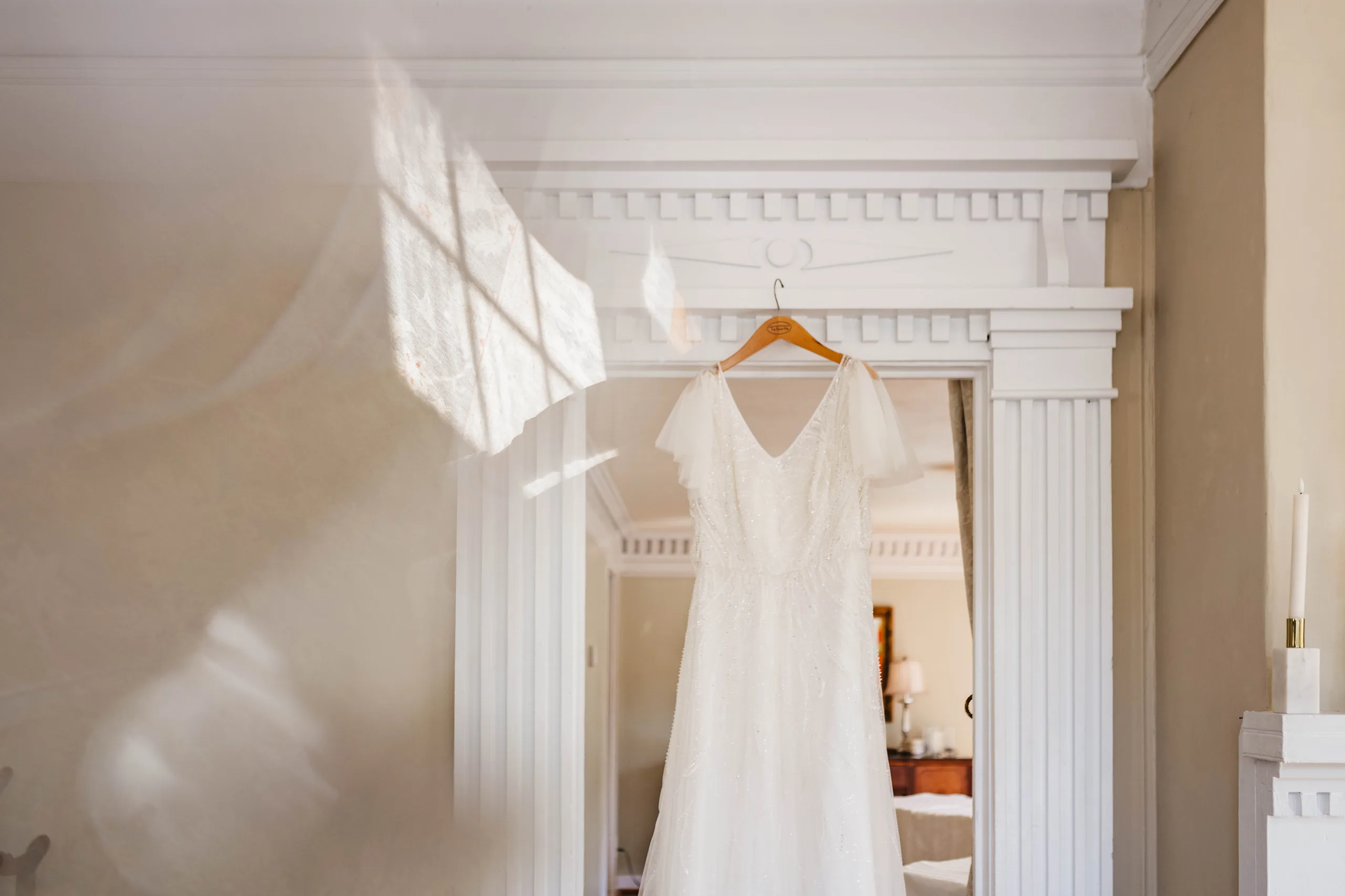 Wedding Details: her gown hanging in the doorway, before their wedding at Naylor Hall in Roswell, GA