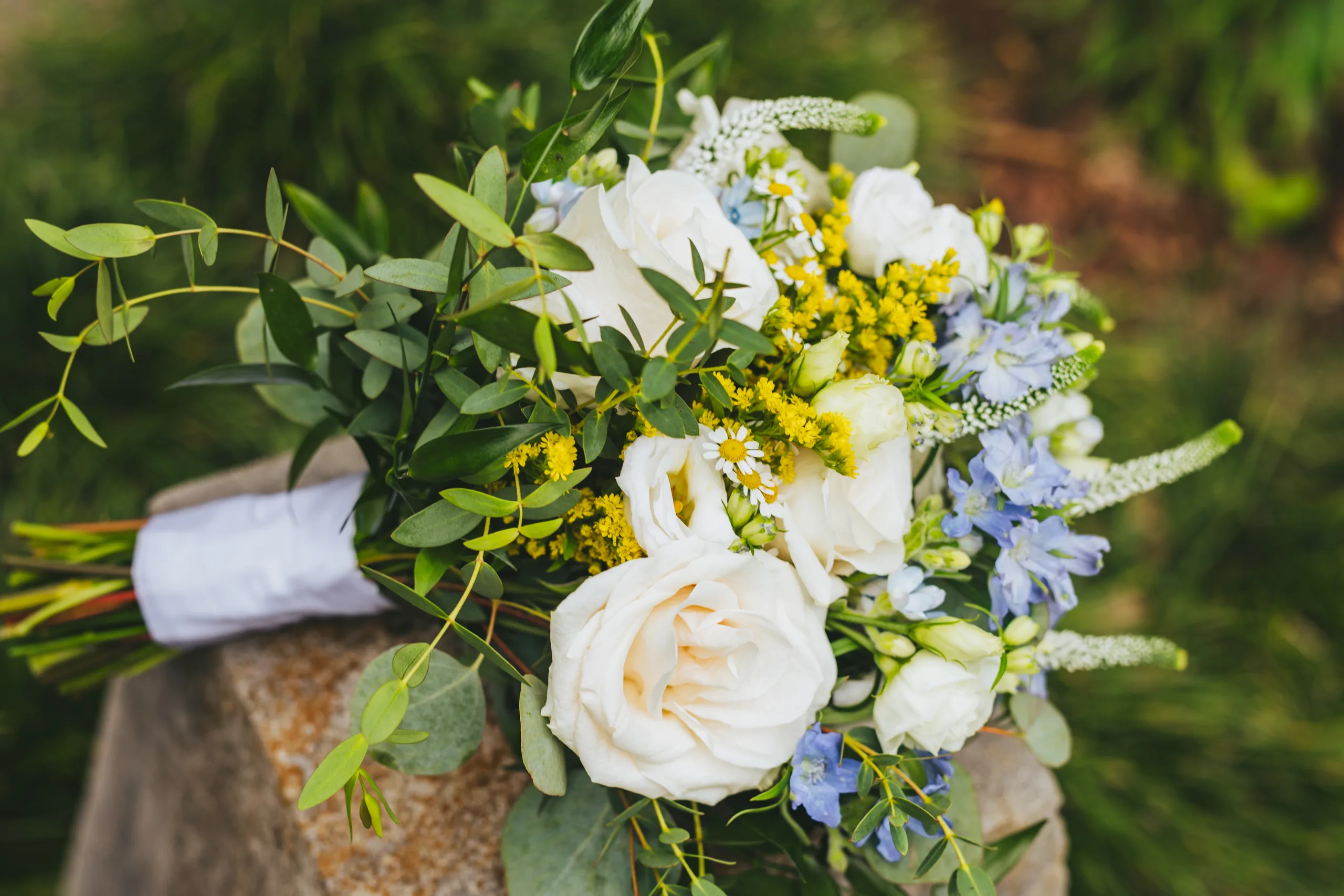 Wedding Florals: her bouquet resting on a rock, at a wedding at Cator Woolford Gardens in Atlanta, GA