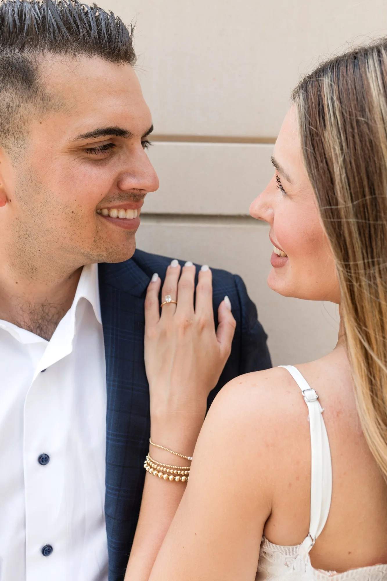 Engagement Ring: her hand and ring on his lapel as they smile at each other, at their engagement session at the Georgia State Capitol in Atlanta, GA