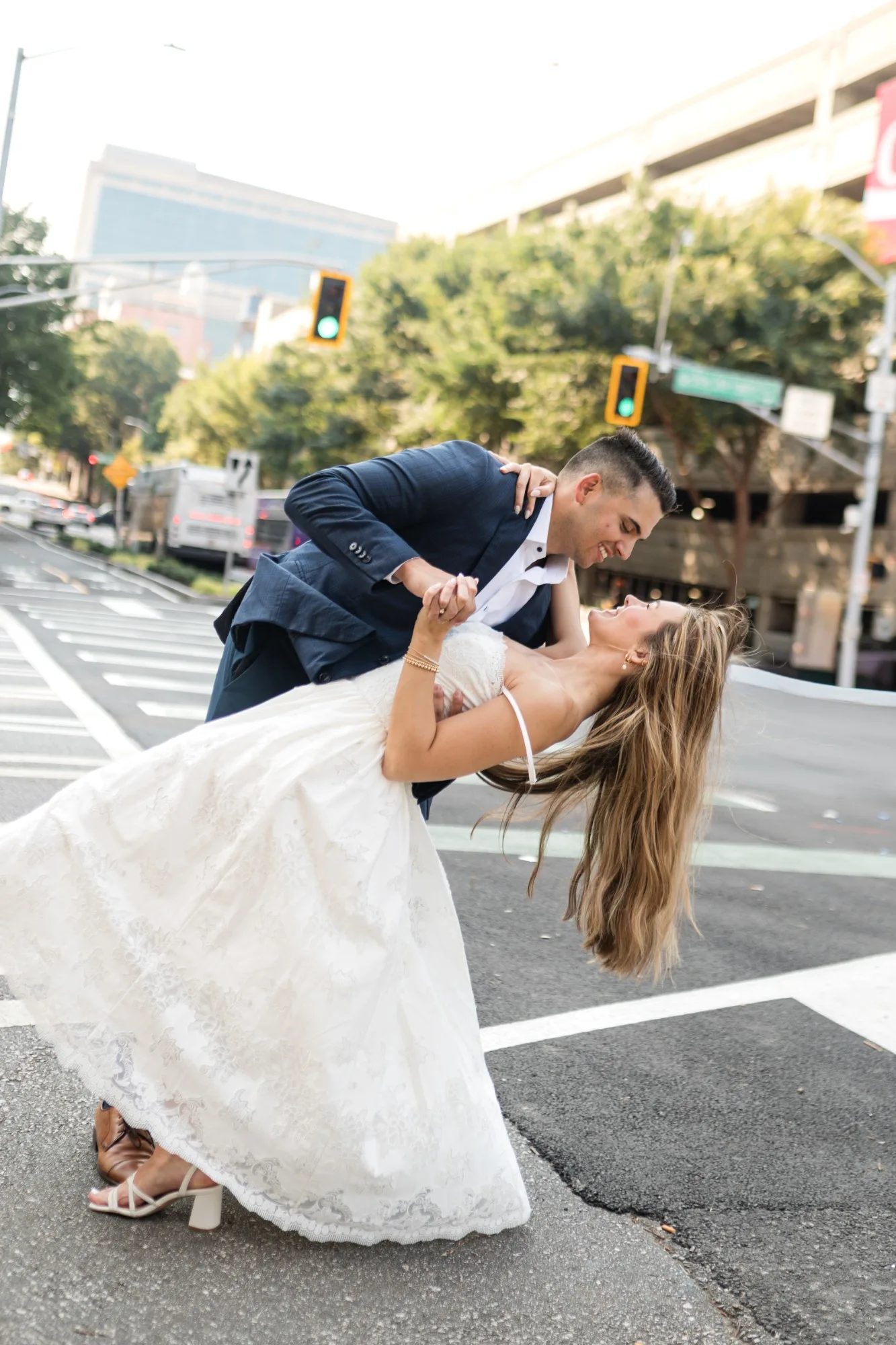 Downtown Atlanta: a dip in the crosswalk under the traffic lights, at their engagement session near the Georgia State Capitol in Atlanta, GA