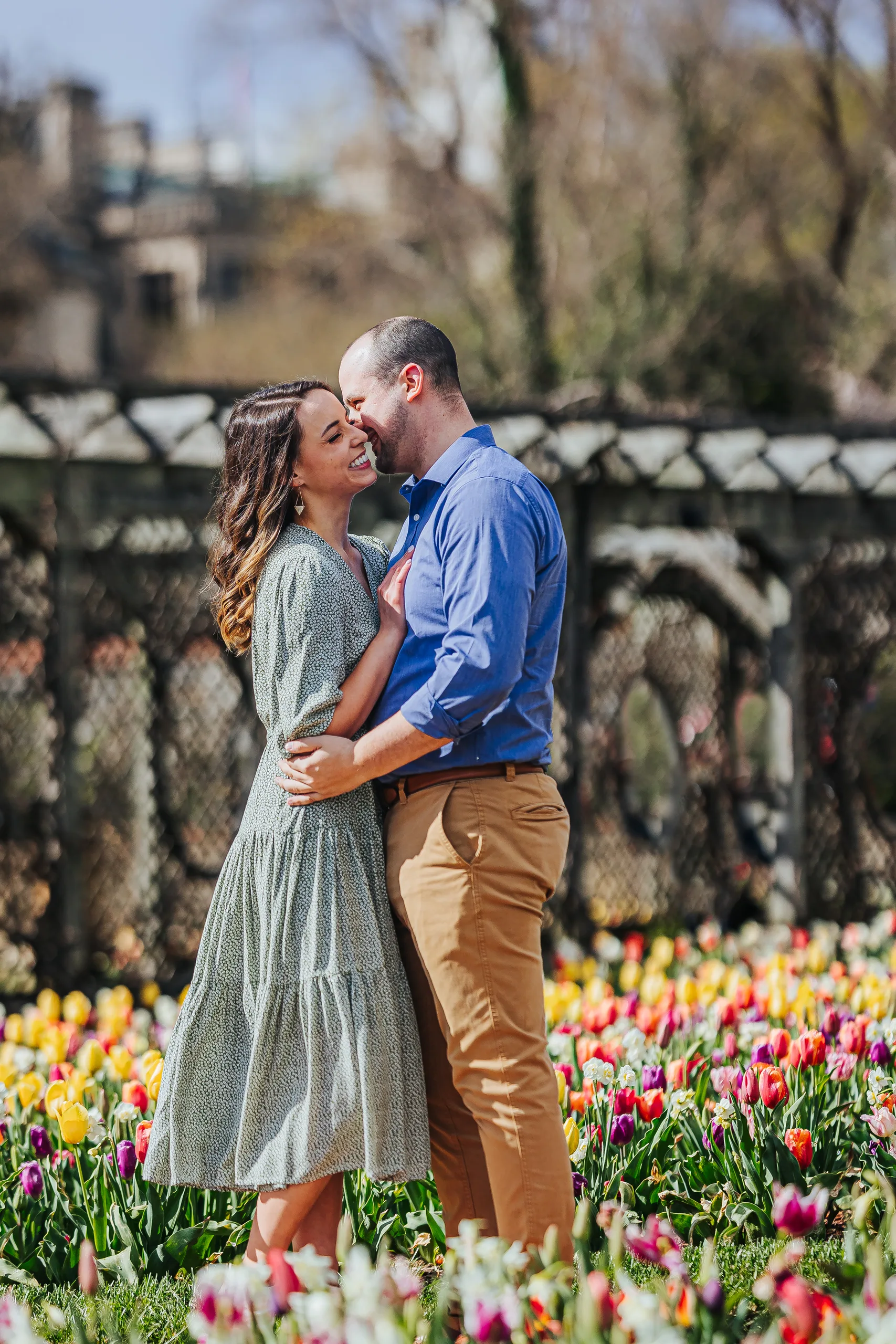 Walled Garden: a kiss on her cheek by the tulip beds, at their engagement session at Biltmore Estate in Asheville, NC