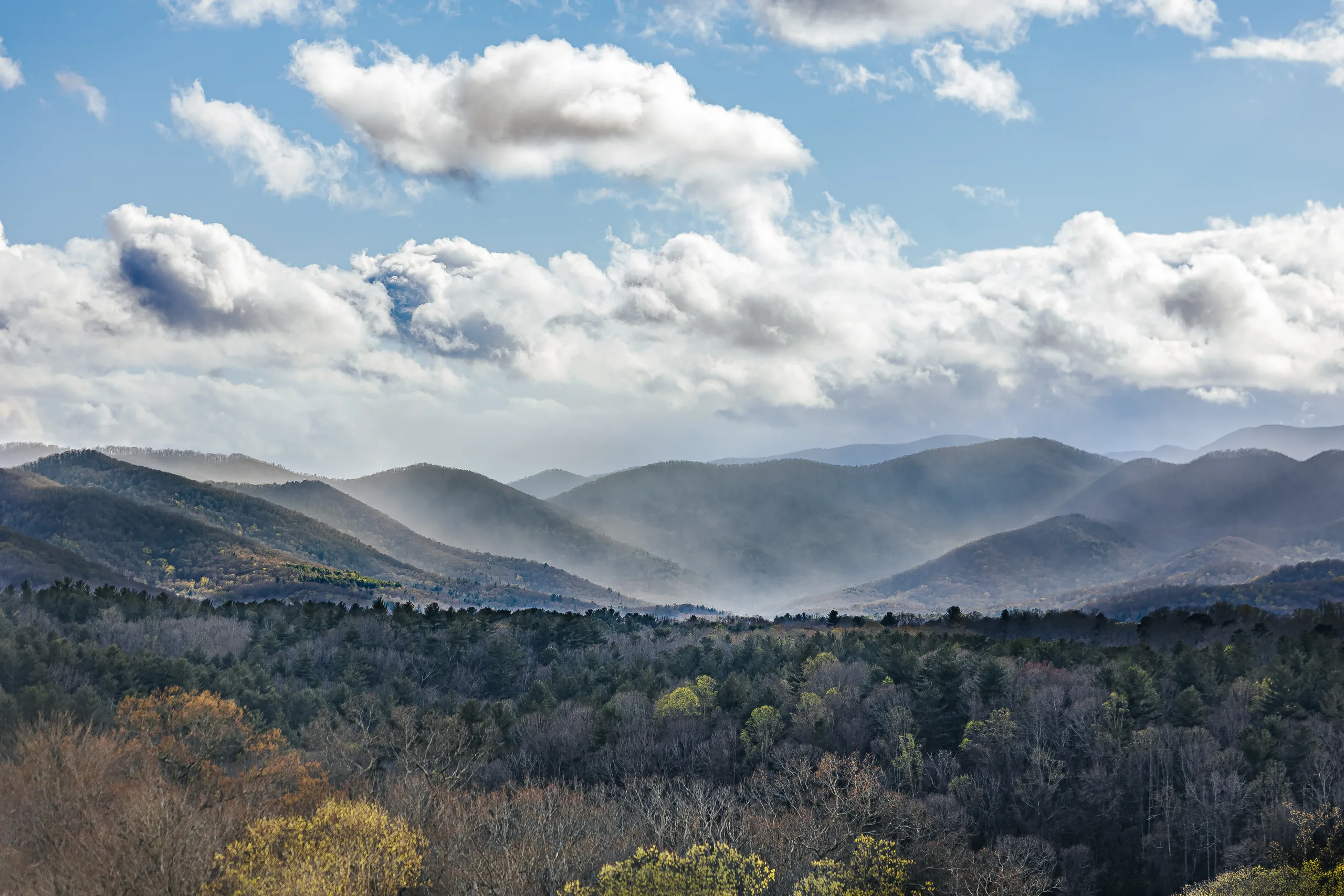 Scenic: the Blue Ridge Mountains with clouds rolling over, at their engagement session at Biltmore Estate in Asheville, NC