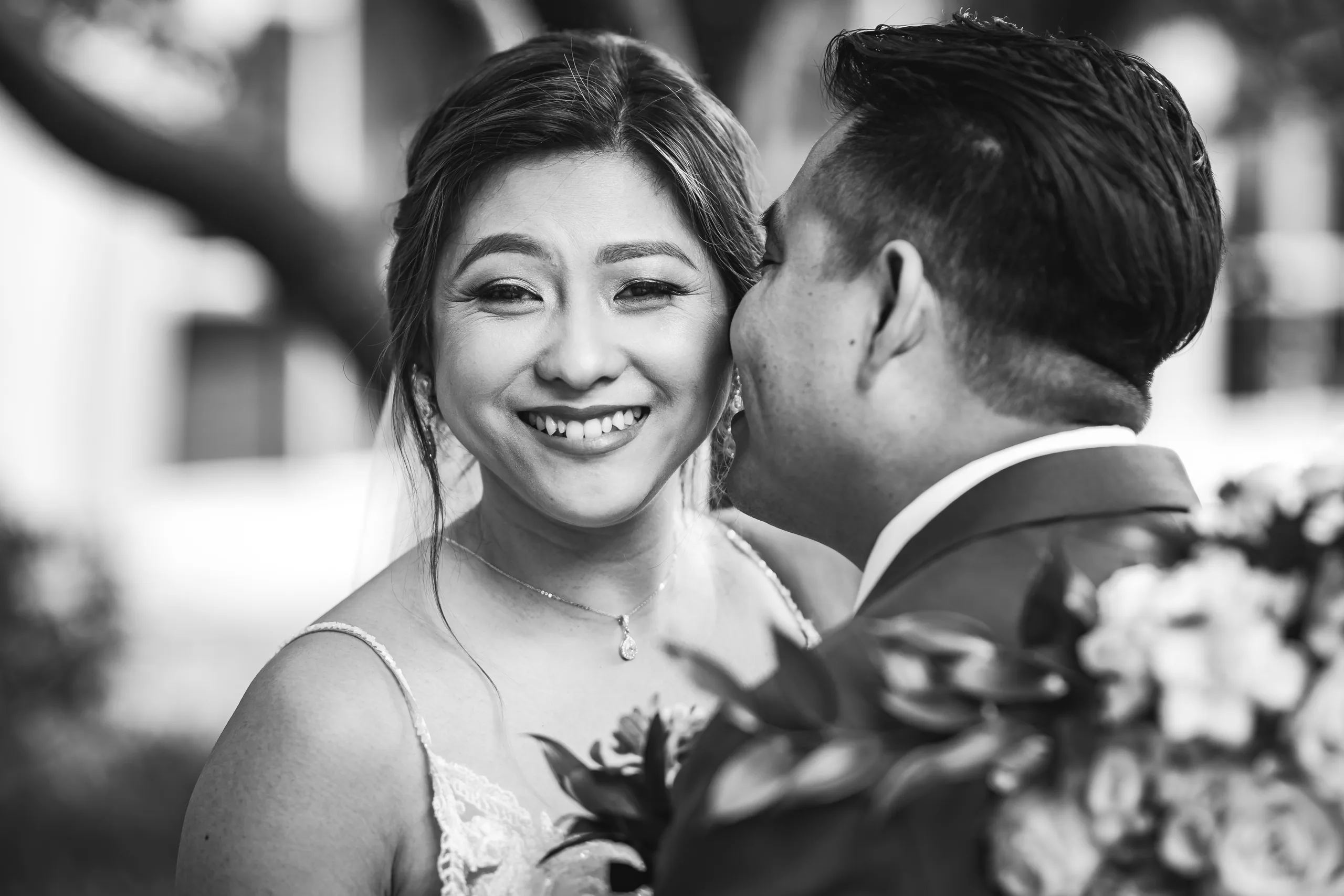 First Look: a kiss on the cheek, in black and white before their wedding at Holy Cross Catholic Church in Atlanta, GA