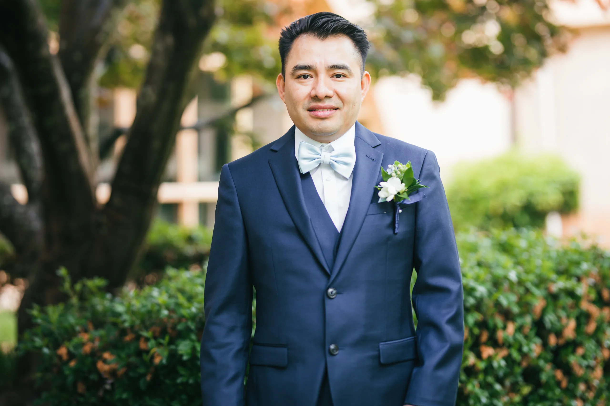 Wedding Formals: the groom in his navy suit and light blue bow tie before their wedding at Holy Cross Catholic Church in Atlanta, GA