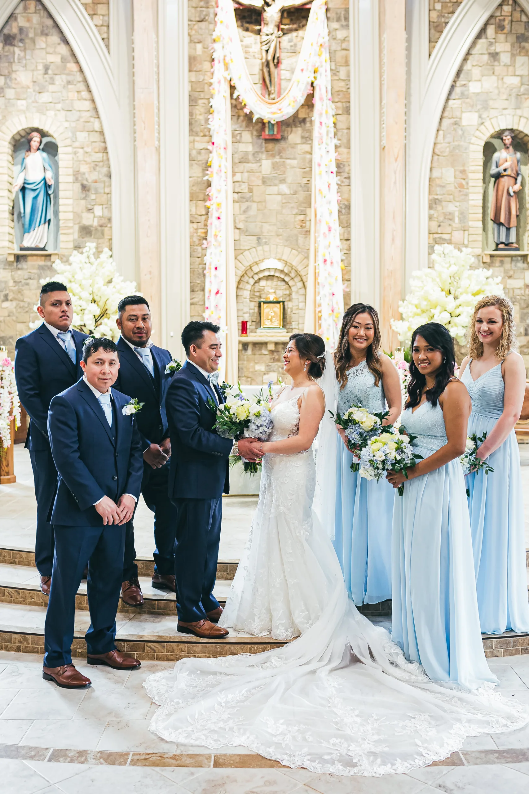 Wedding Party: the wedding party in navy and light blue at the altar at their wedding at Holy Cross Catholic Church in Atlanta, GA