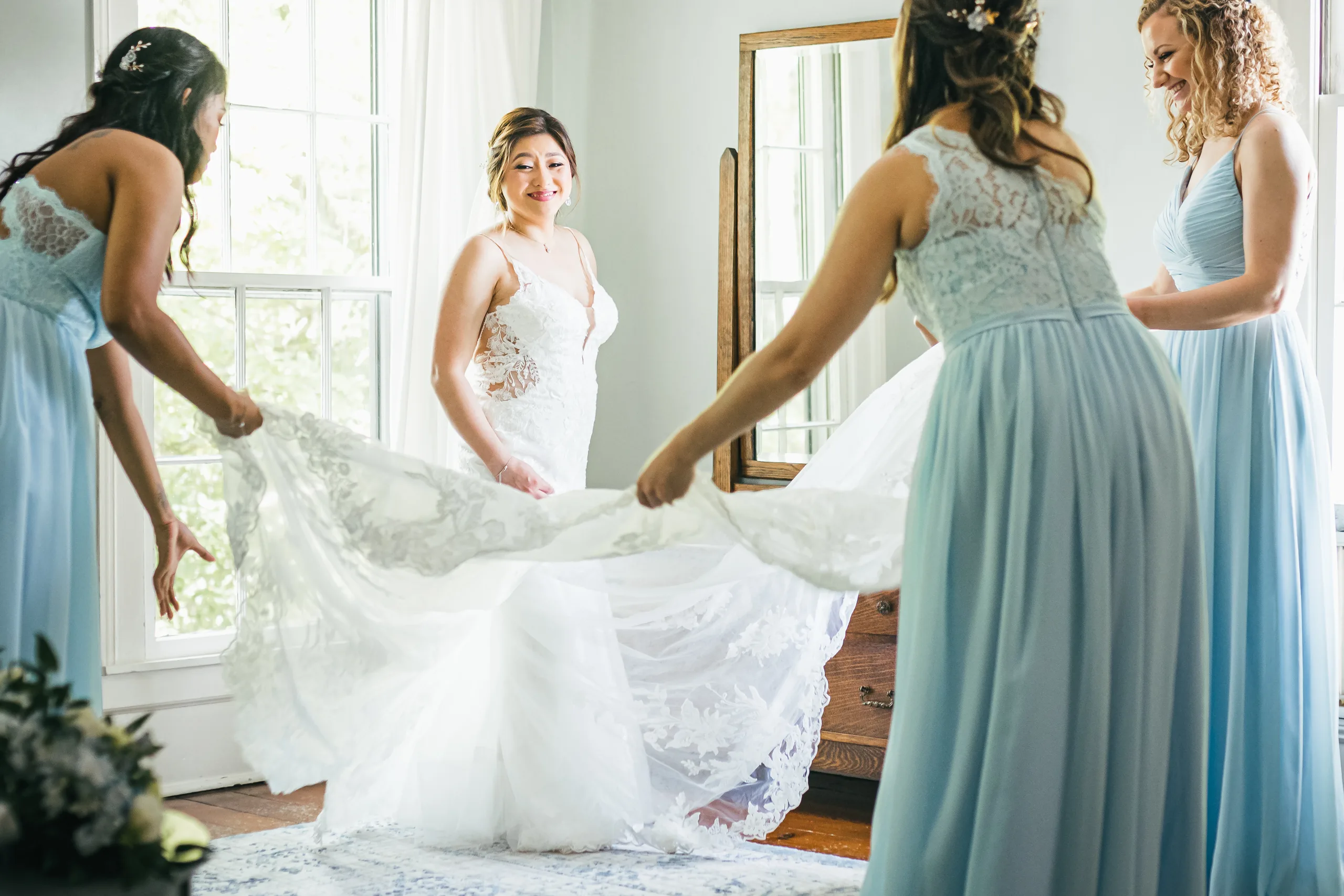 Bridal Portraits: bridesmaids fluffing her train by the window at their wedding at the Payne-Corley House in Duluth, GA