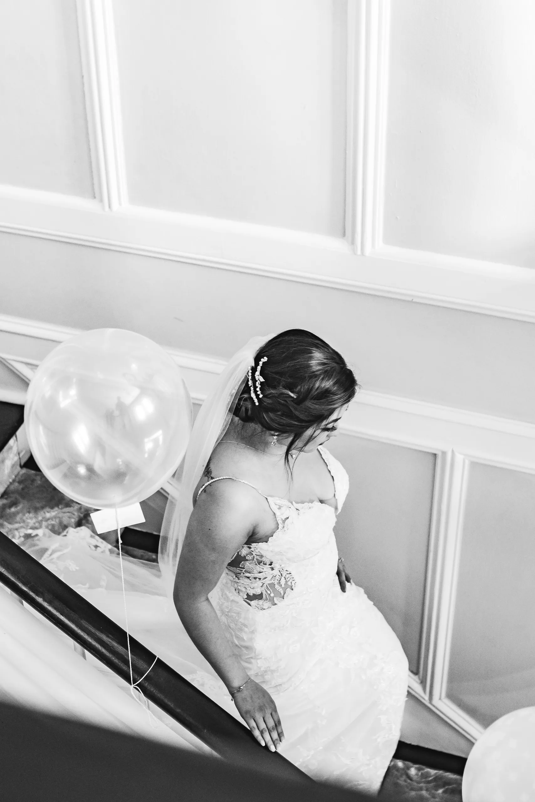 Bridal Portraits: the bride on the stairs from above, in black and white at their wedding at the Payne-Corley House in Duluth, GA