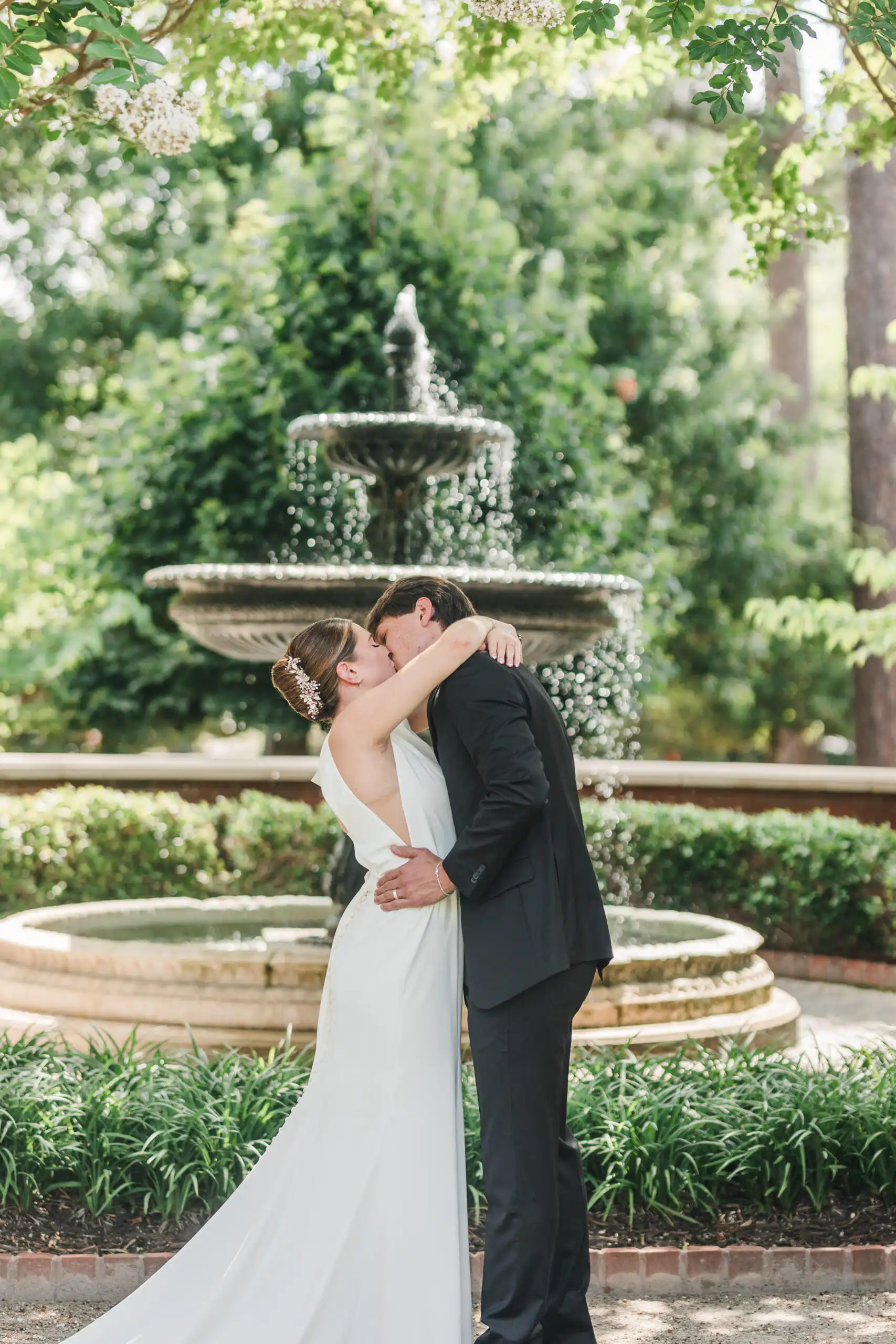 Wedding Formals: the couple kissing in front of the tiered fountain, at their elopement at Brooke Street Park in Alpharetta, GA
