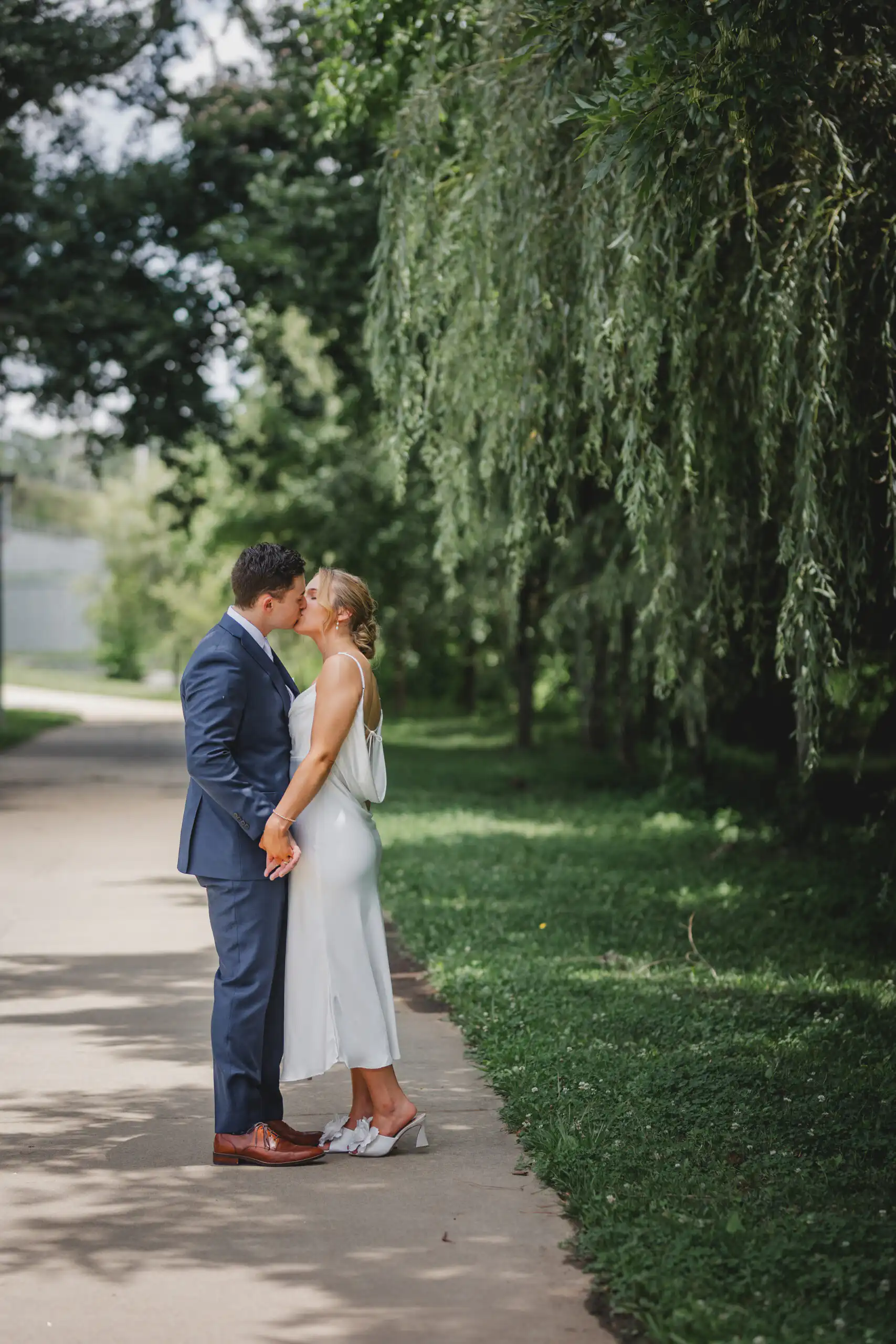 Wedding Formals: a kiss on the path beneath the willow, after their courthouse wedding at Brookhaven City Hall in Brookhaven, GA