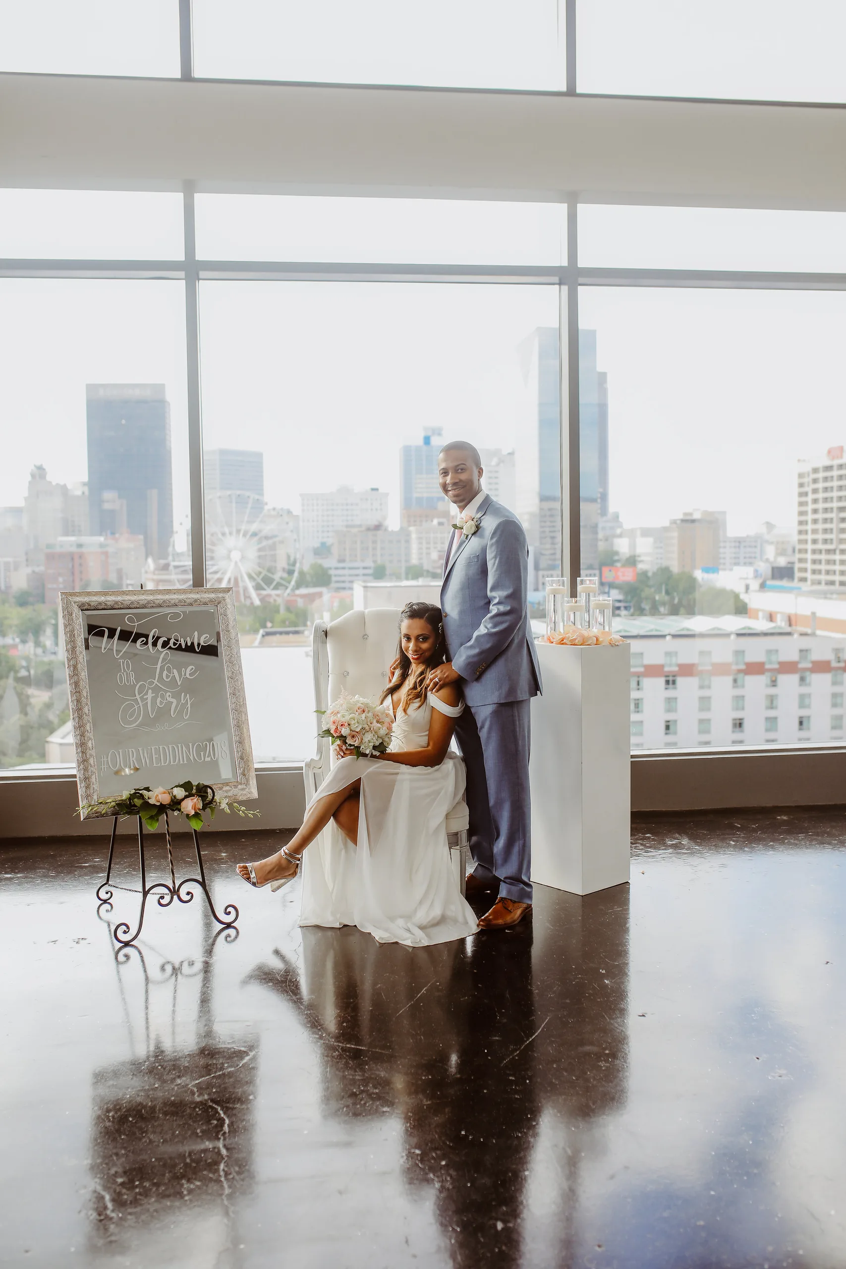 Wedding Formals: the bride in the white armchair with the groom beside her and the welcome sign, at their elopement at Ventanas in Atlanta, GA