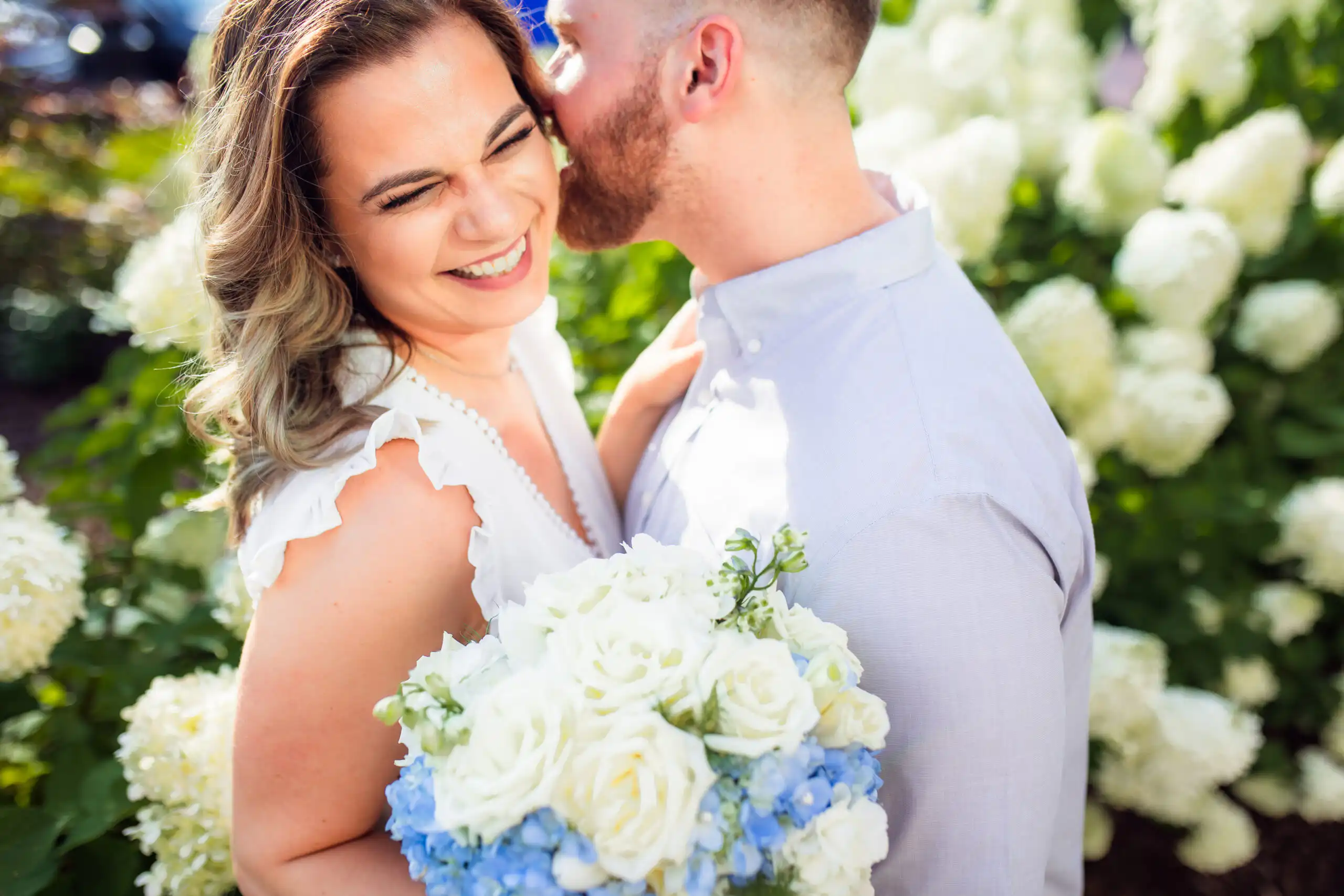 Wedding Formals: a kiss on the cheek among the white hydrangeas, after their courthouse wedding in Marietta, GA