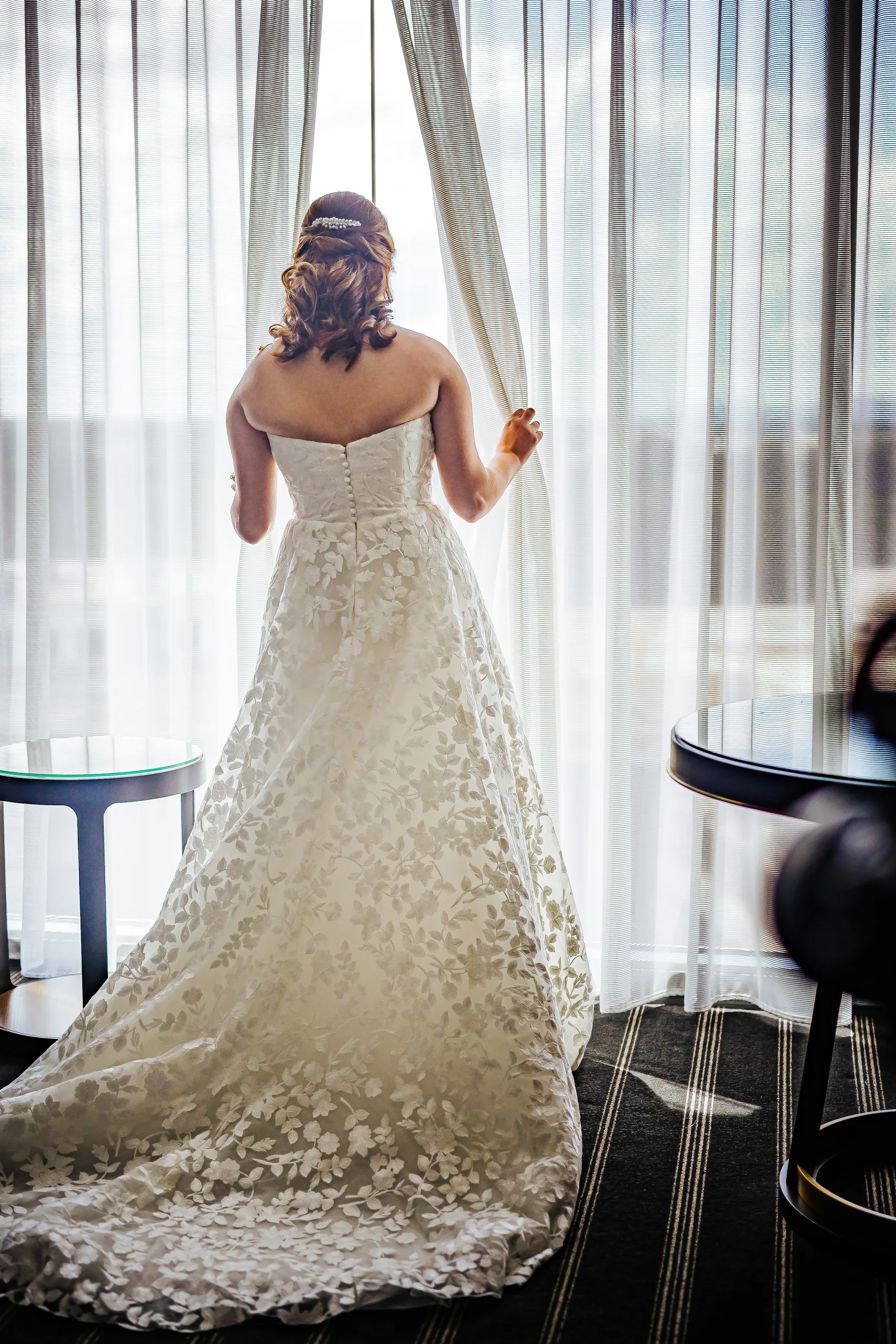 Getting Ready: the bride standing at the hotel window before their wedding at the Omni Hotel at The Battery in Atlanta, GA