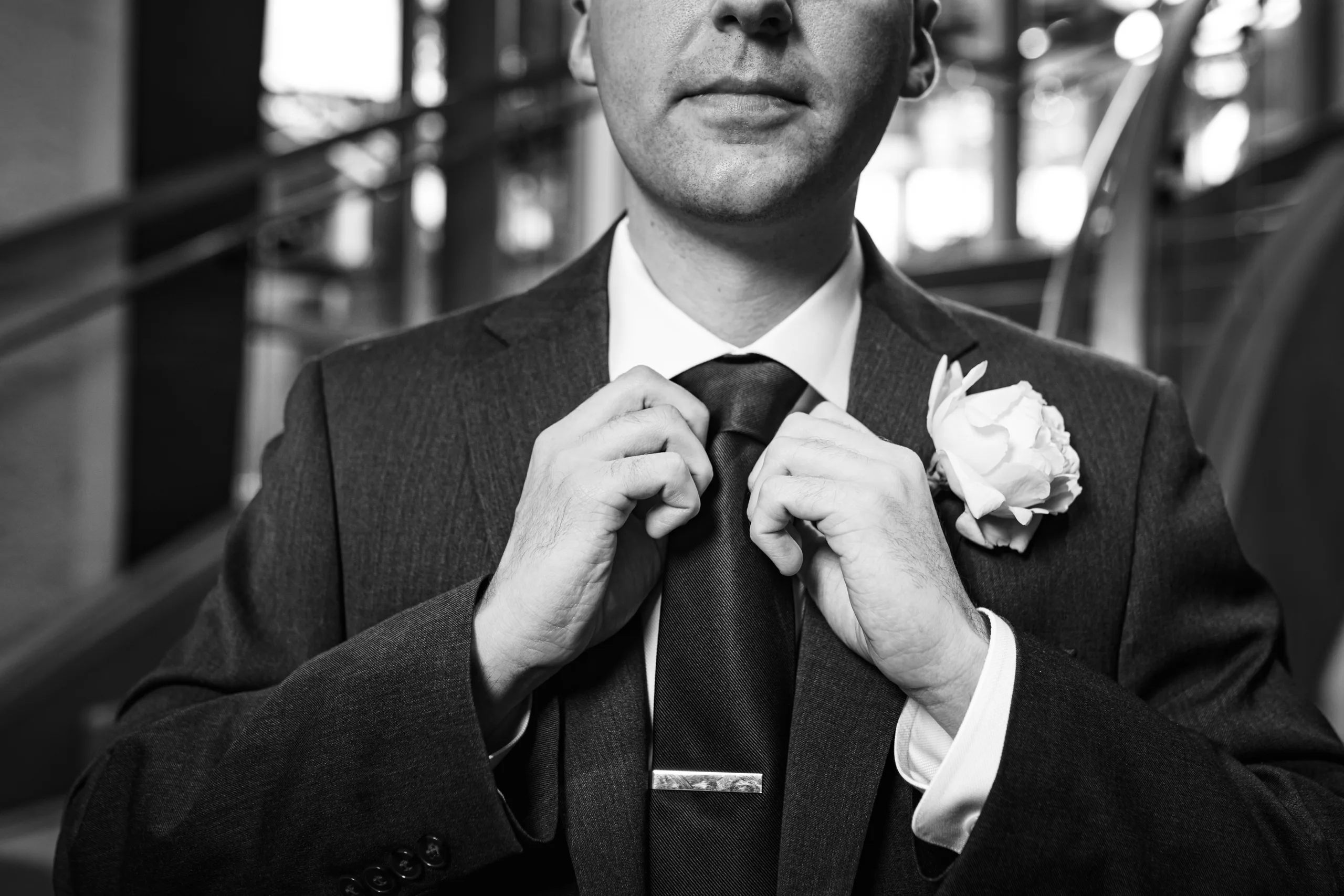 Wedding Formals: the groom straightening his tie, in black and white before their wedding at the Omni Hotel at The Battery in Atlanta, GA