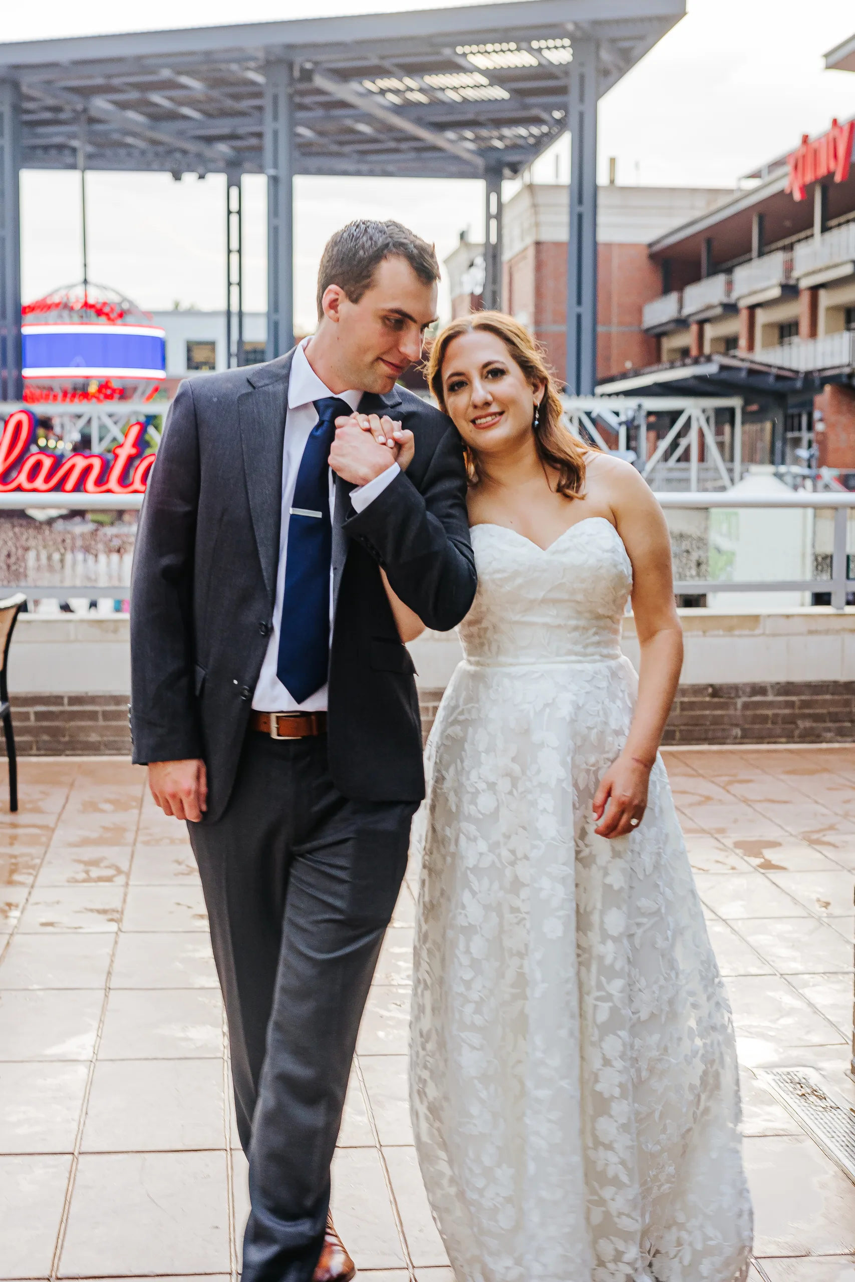 Wedding Formals: walking together on the terrace at The Battery at their wedding at the Omni Hotel at The Battery in Atlanta, GA