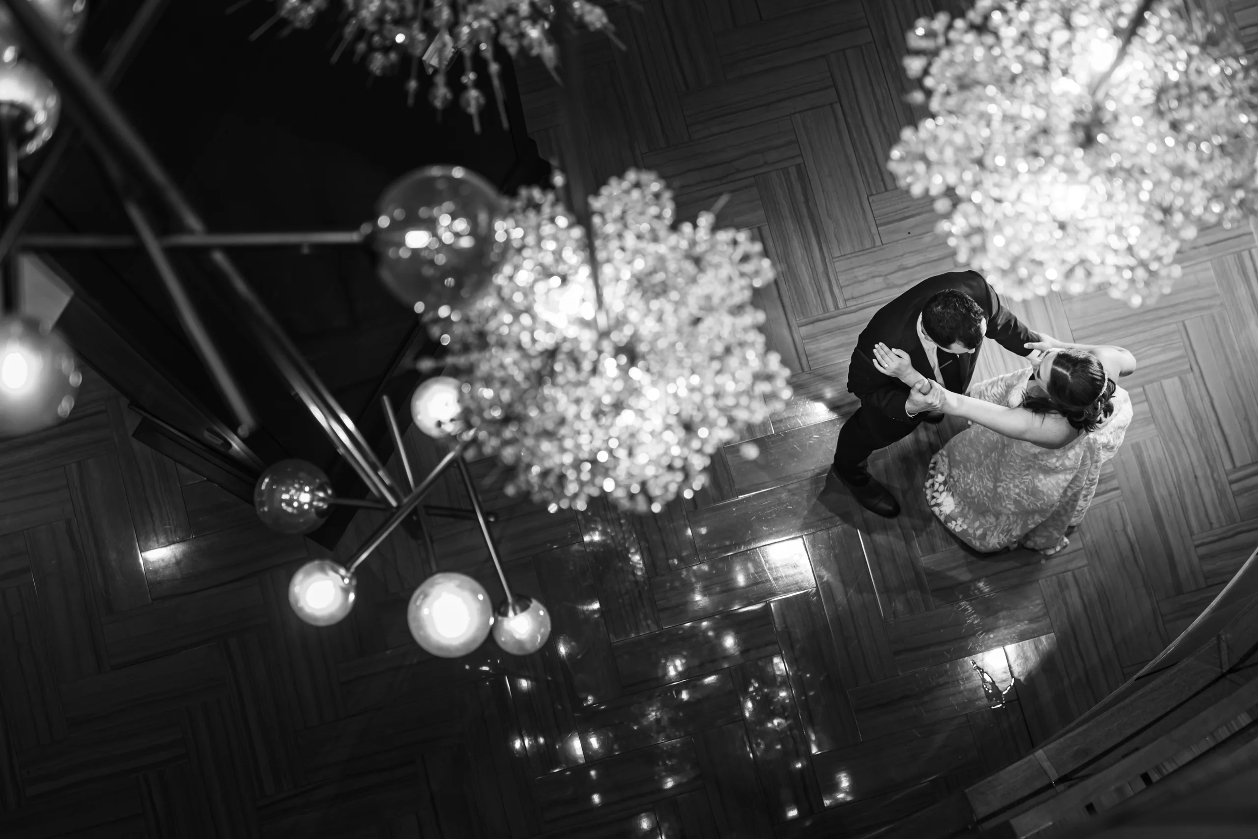 Wedding Formals: a dance under the chandeliers seen from above, in black and white at their wedding at the Omni Hotel at The Battery in Atlanta, GA
