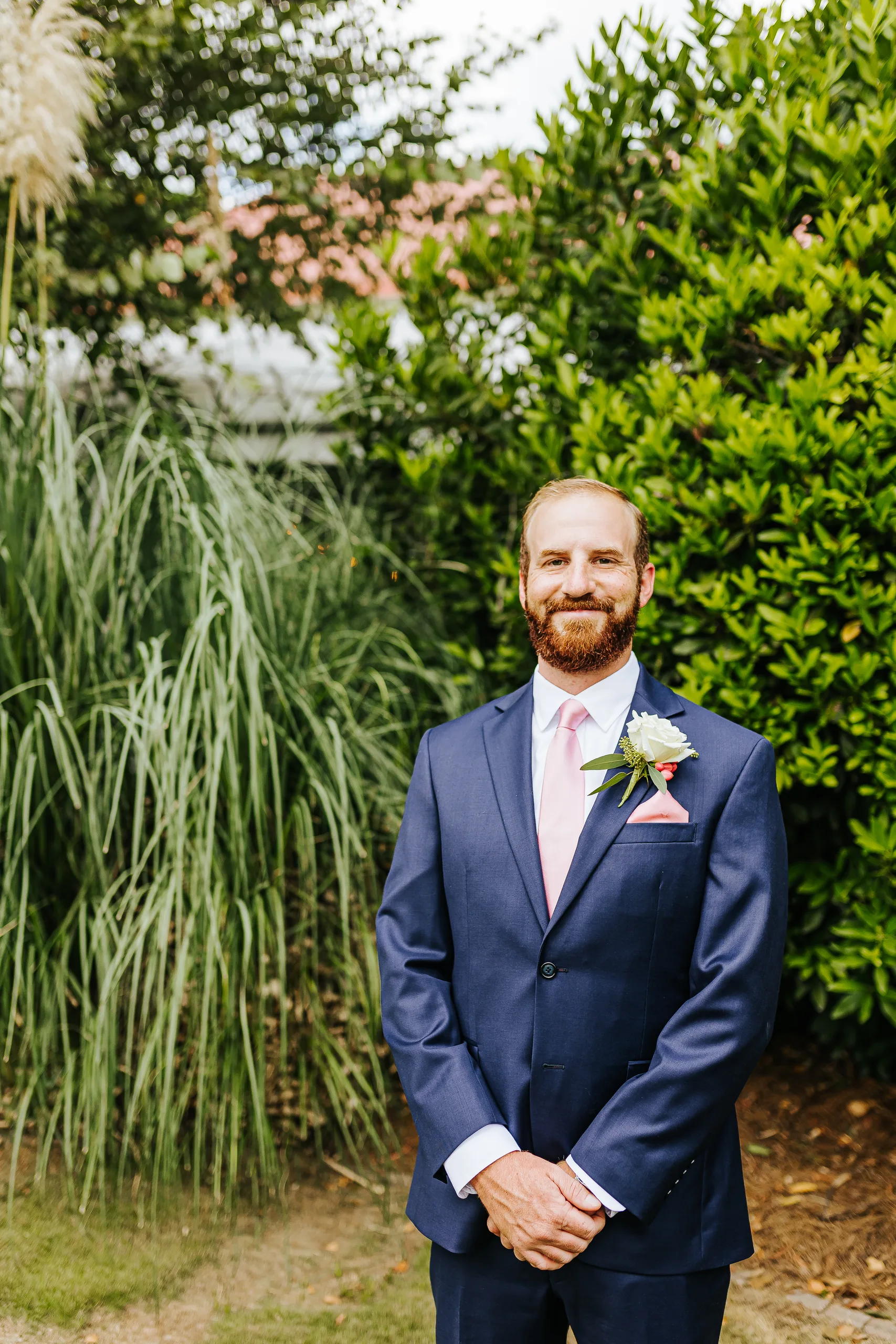 Wedding Formals: the groom in his navy suit by the tall grasses, at their wedding at The Piedmont Room in Atlanta, GA