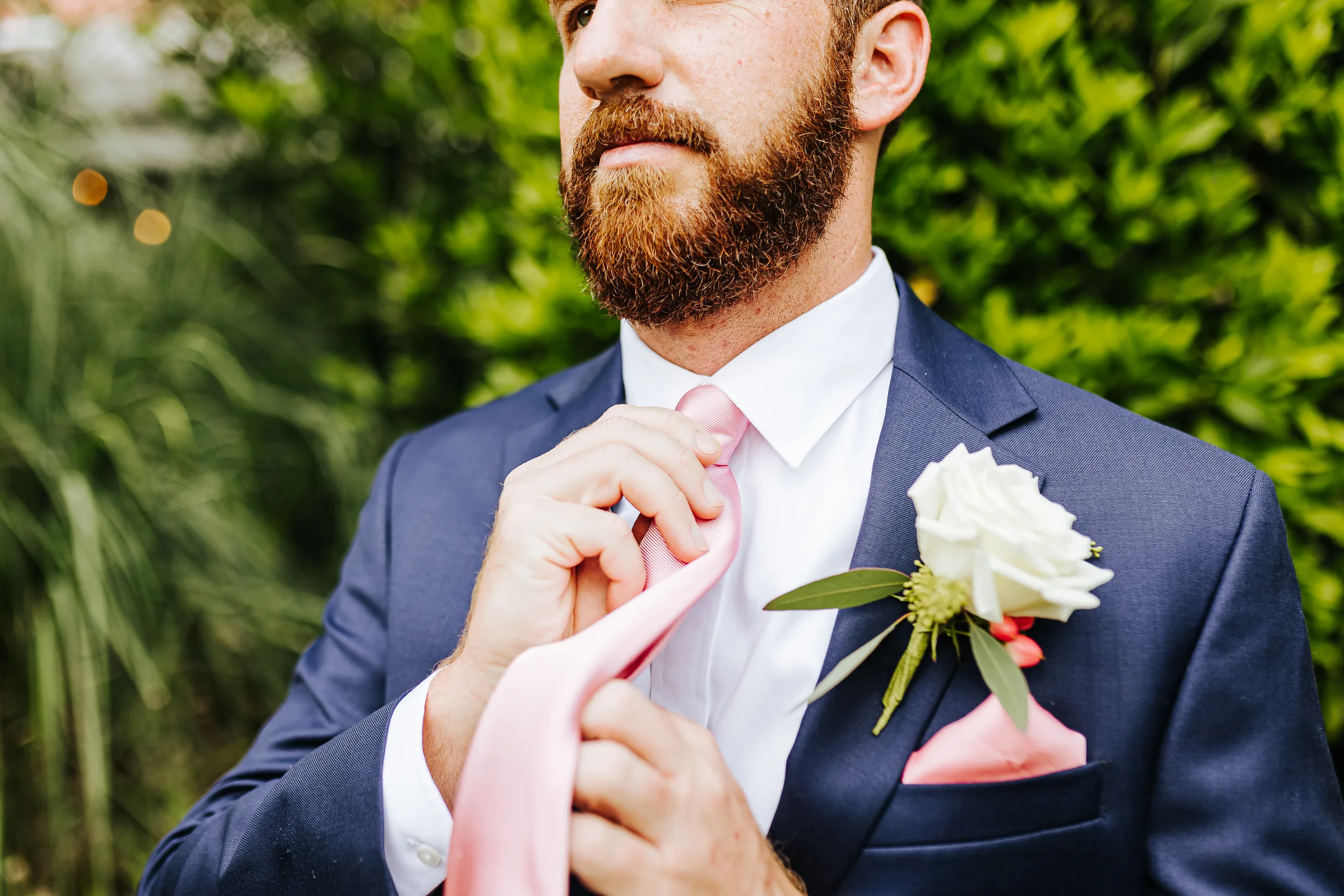 Wedding Formals: the groom fixing his pink tie, at their wedding at The Piedmont Room in Atlanta, GA