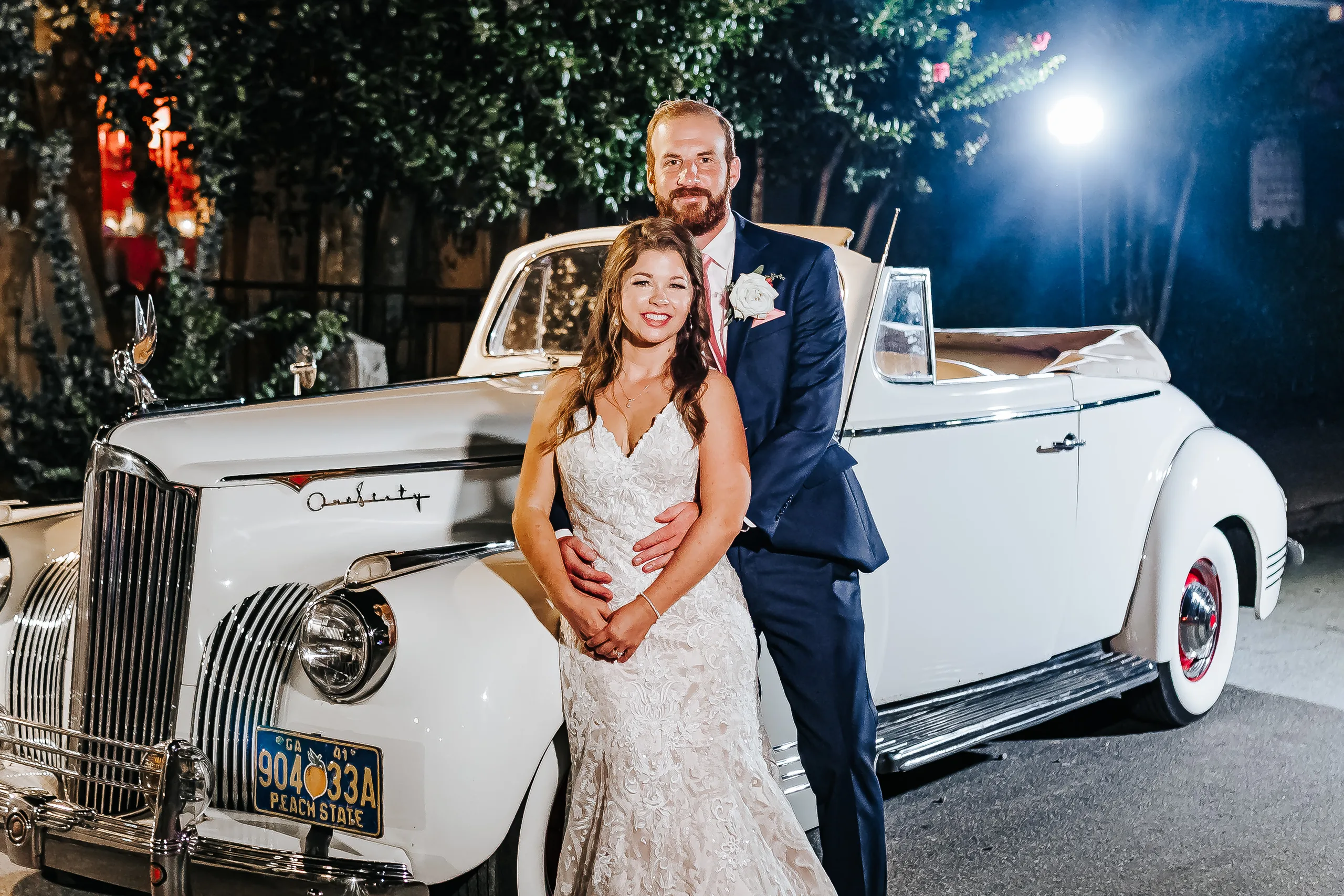Wedding Formals: the couple against the vintage white Packard convertible at night, at their wedding at The Piedmont Room in Atlanta, GA