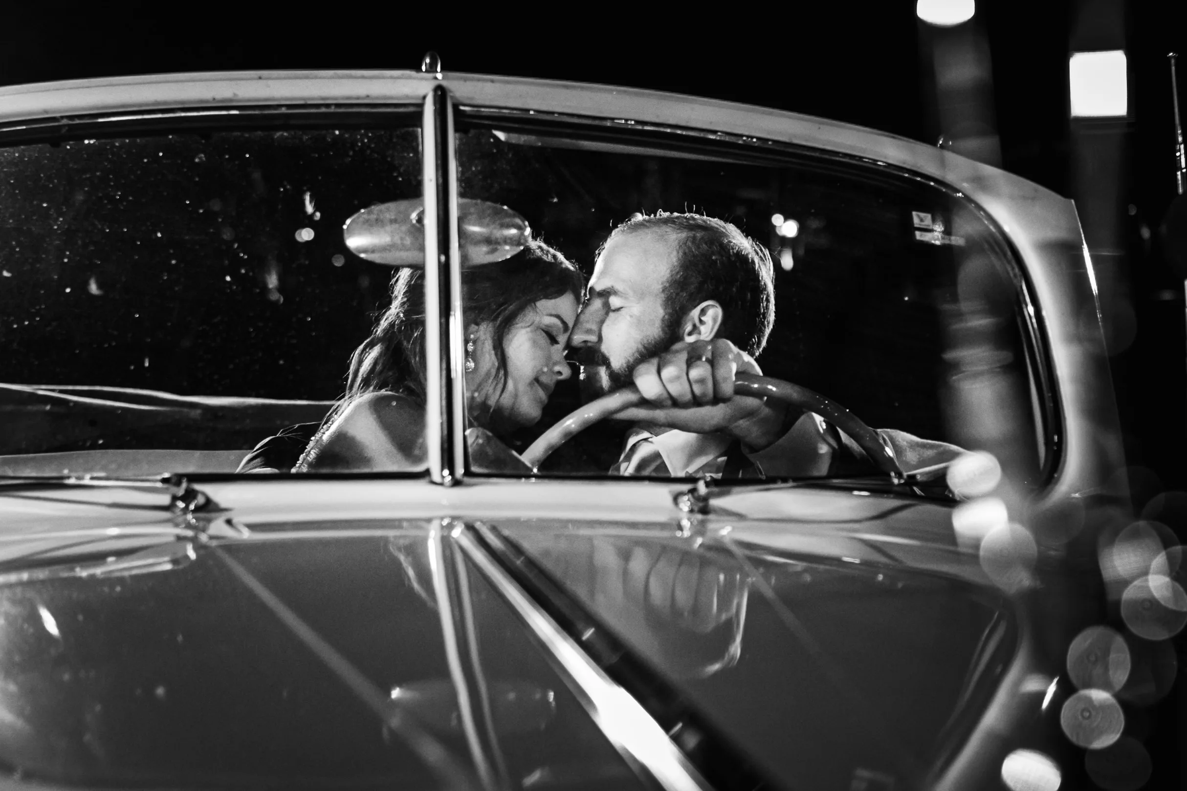 Wedding Formals: a kiss in the vintage Packard convertible, in black and white, at their wedding at The Piedmont Room in Atlanta, GA