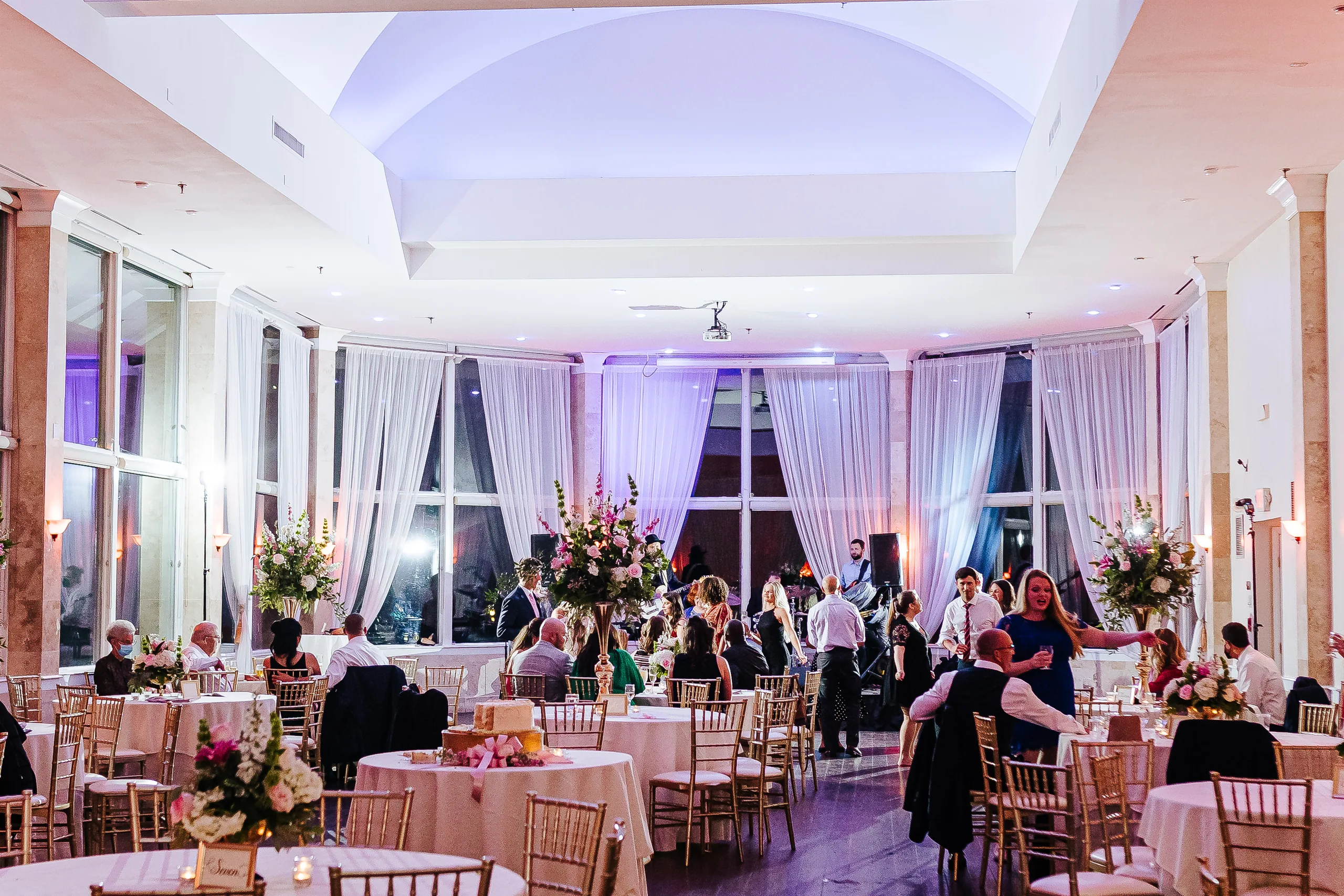 Reception: the reception room at night with purple uplighting, at their wedding at The Piedmont Room in Atlanta, GA