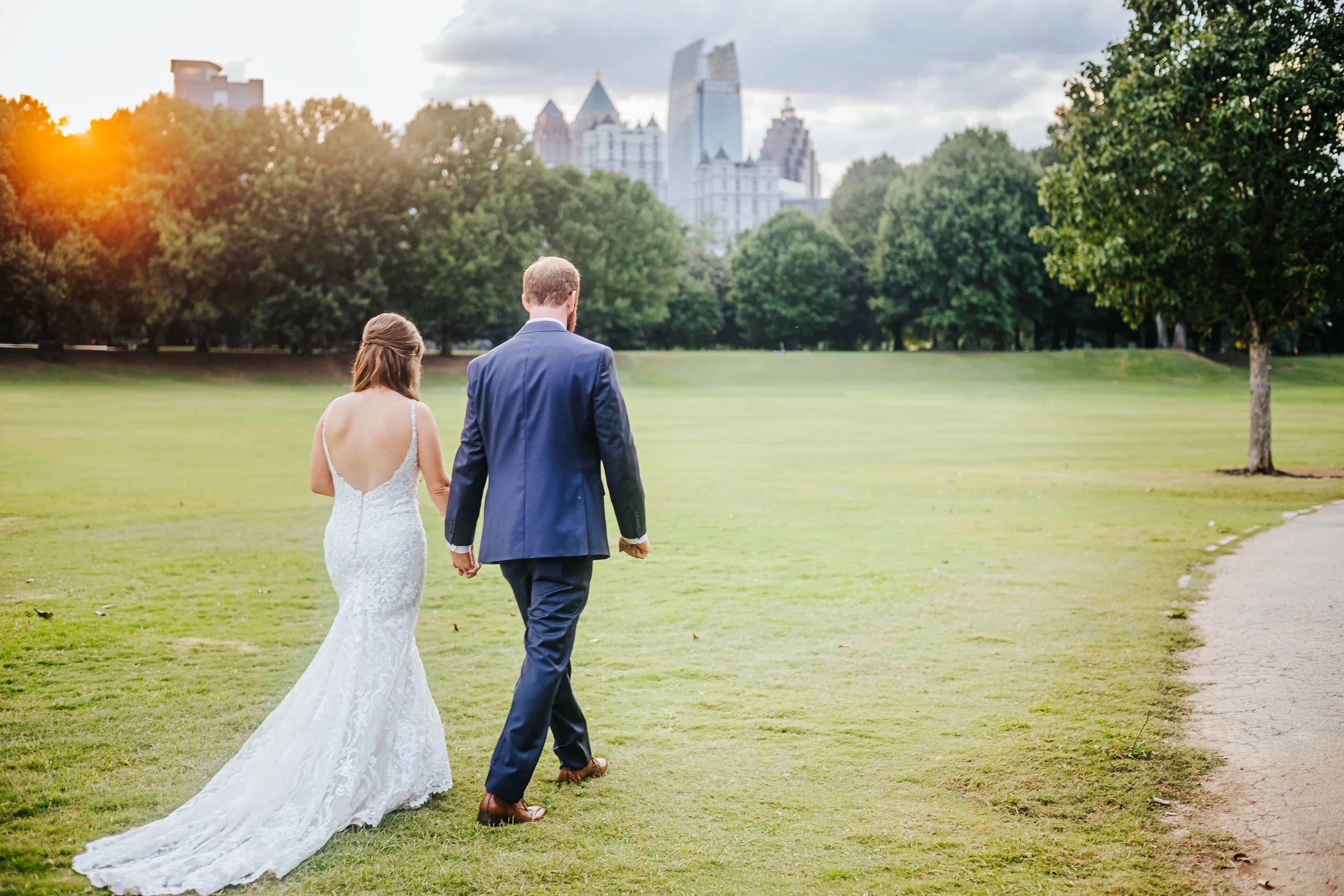 Wedding Formals: walking toward the Midtown skyline on the meadow in Piedmont Park, at their wedding at The Piedmont Room in Atlanta, GA