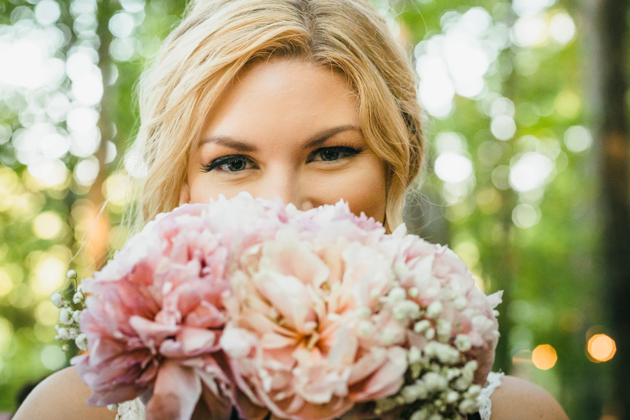 Bridal Portraits: the bride peeking over her peony bouquet, at their wedding at Atlanta Evergreen Lakeside Resort in Stone Mountain, GA