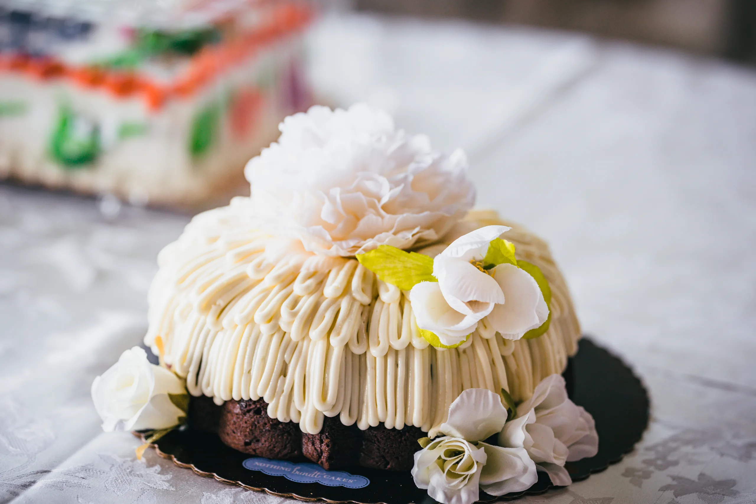 Wedding Cake Details: a white frosted bundt cake topped with flowers, at a wedding at Atlanta Evergreen Lakeside Resort in Stone Mountain, GA