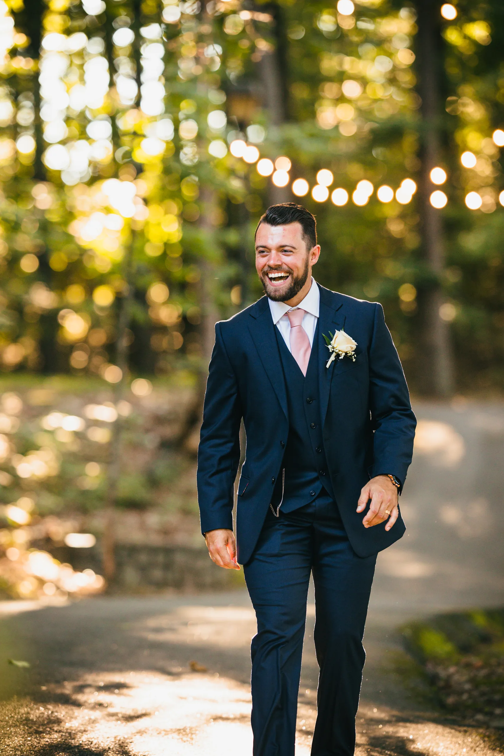 Wedding Formals: the groom laughing on the path in the woods, at their wedding at Atlanta Evergreen Lakeside Resort in Stone Mountain, GA