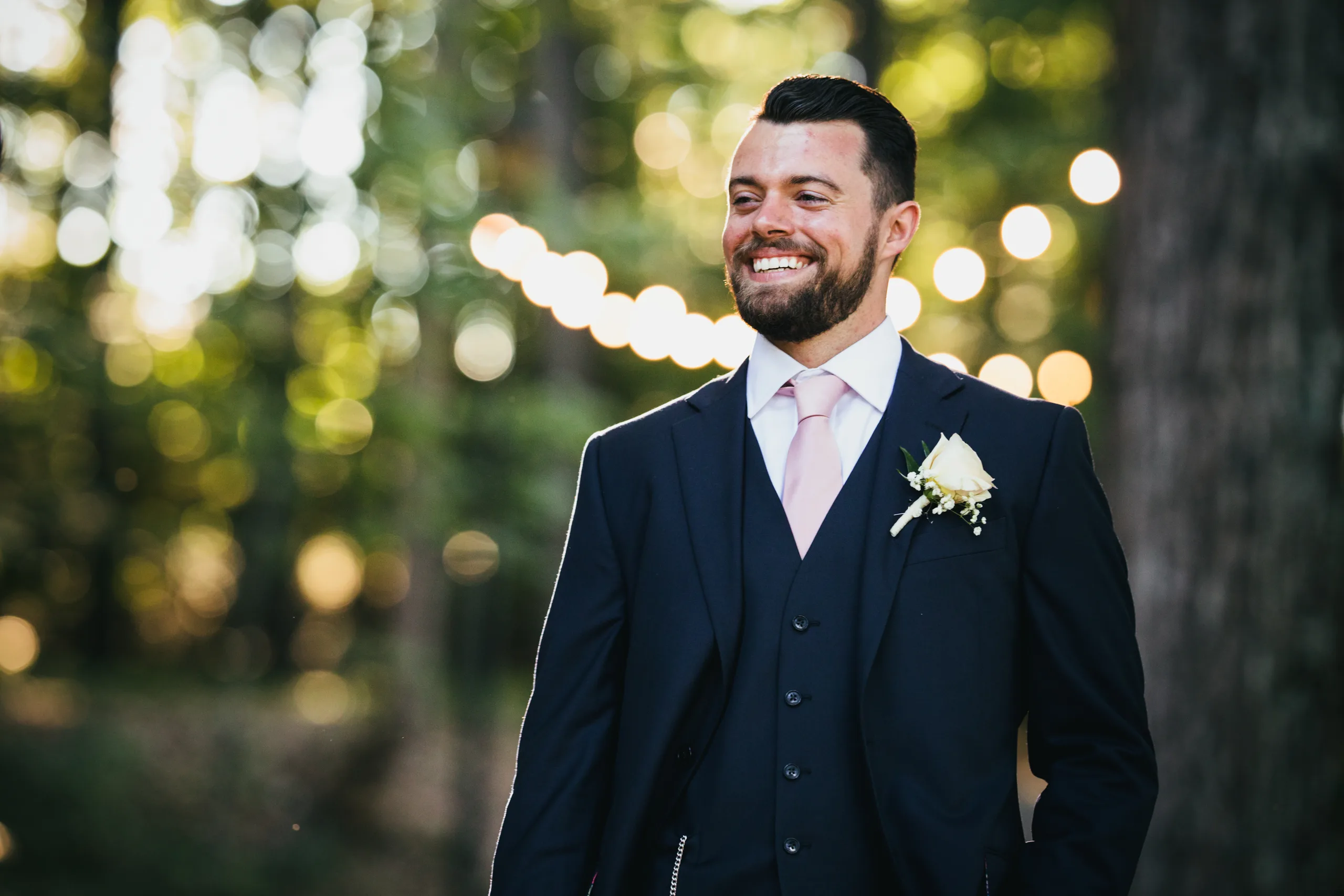 Wedding Formals: the groom smiling under the string lights, at their wedding at Atlanta Evergreen Lakeside Resort in Stone Mountain, GA