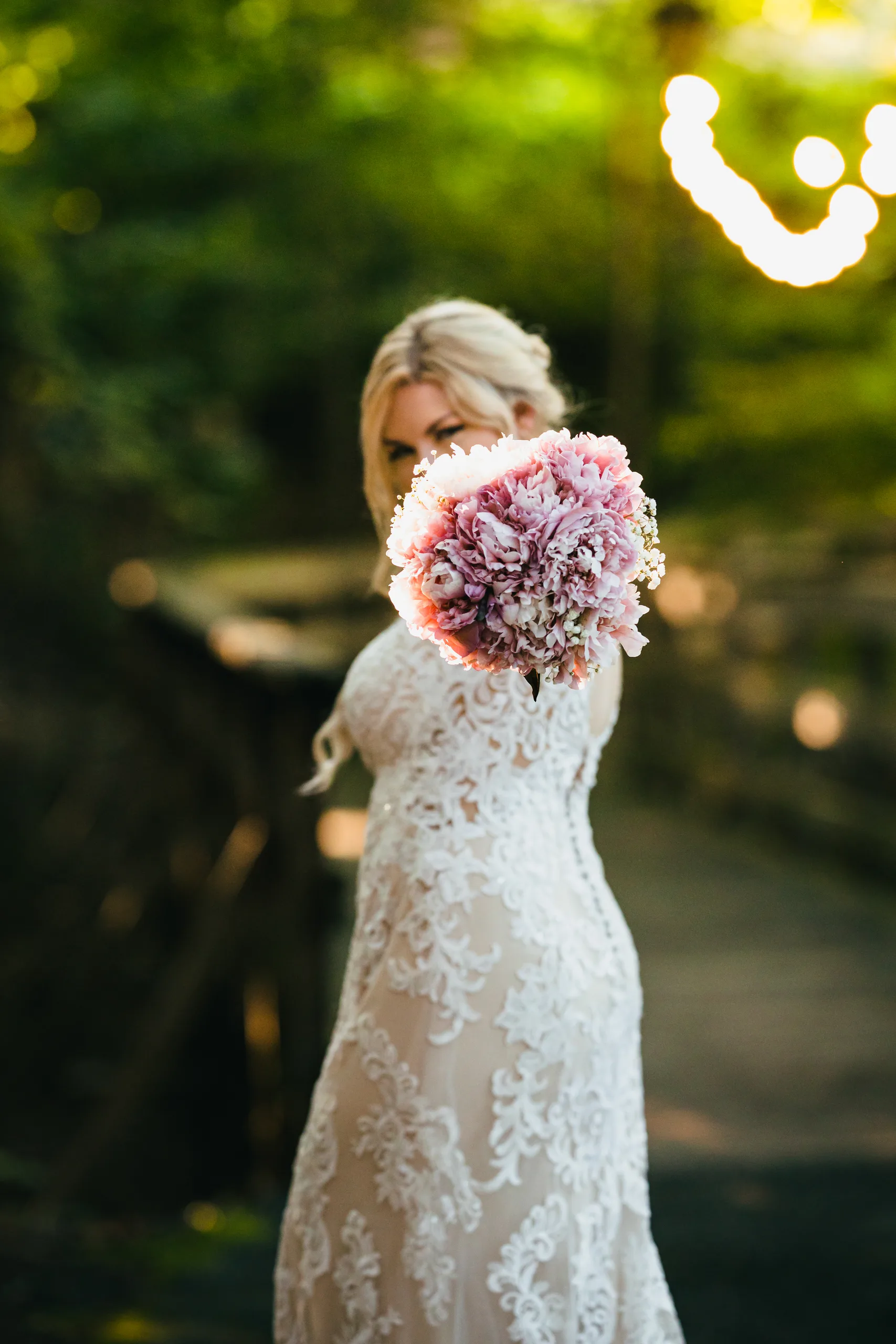 Bridal Portraits: the bride holding her bouquet out toward the camera, at their wedding at Atlanta Evergreen Lakeside Resort in Stone Mountain, GA