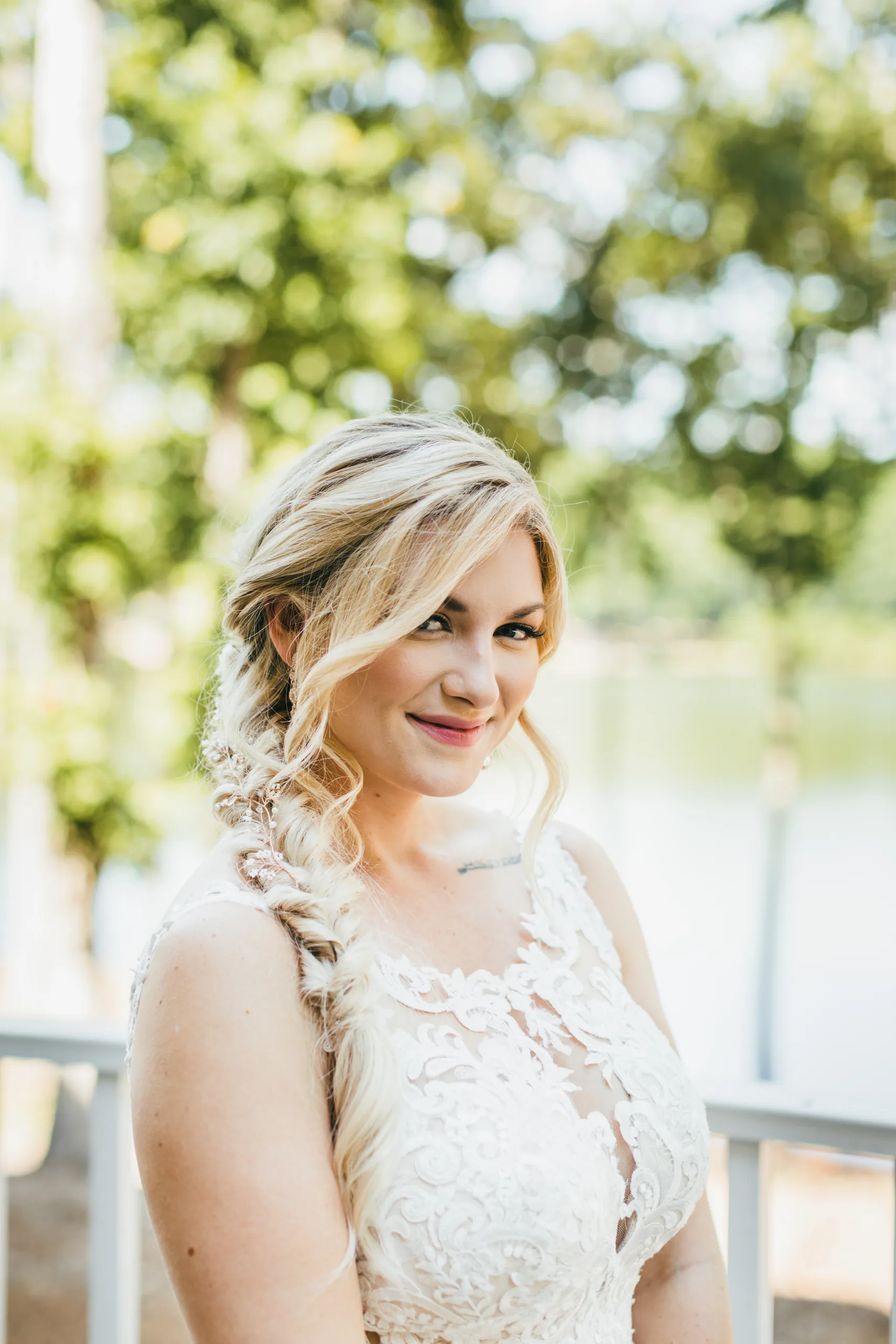 Bridal Portraits: the bride smiling with the lake behind her, at their wedding at Atlanta Evergreen Lakeside Resort in Stone Mountain, GA