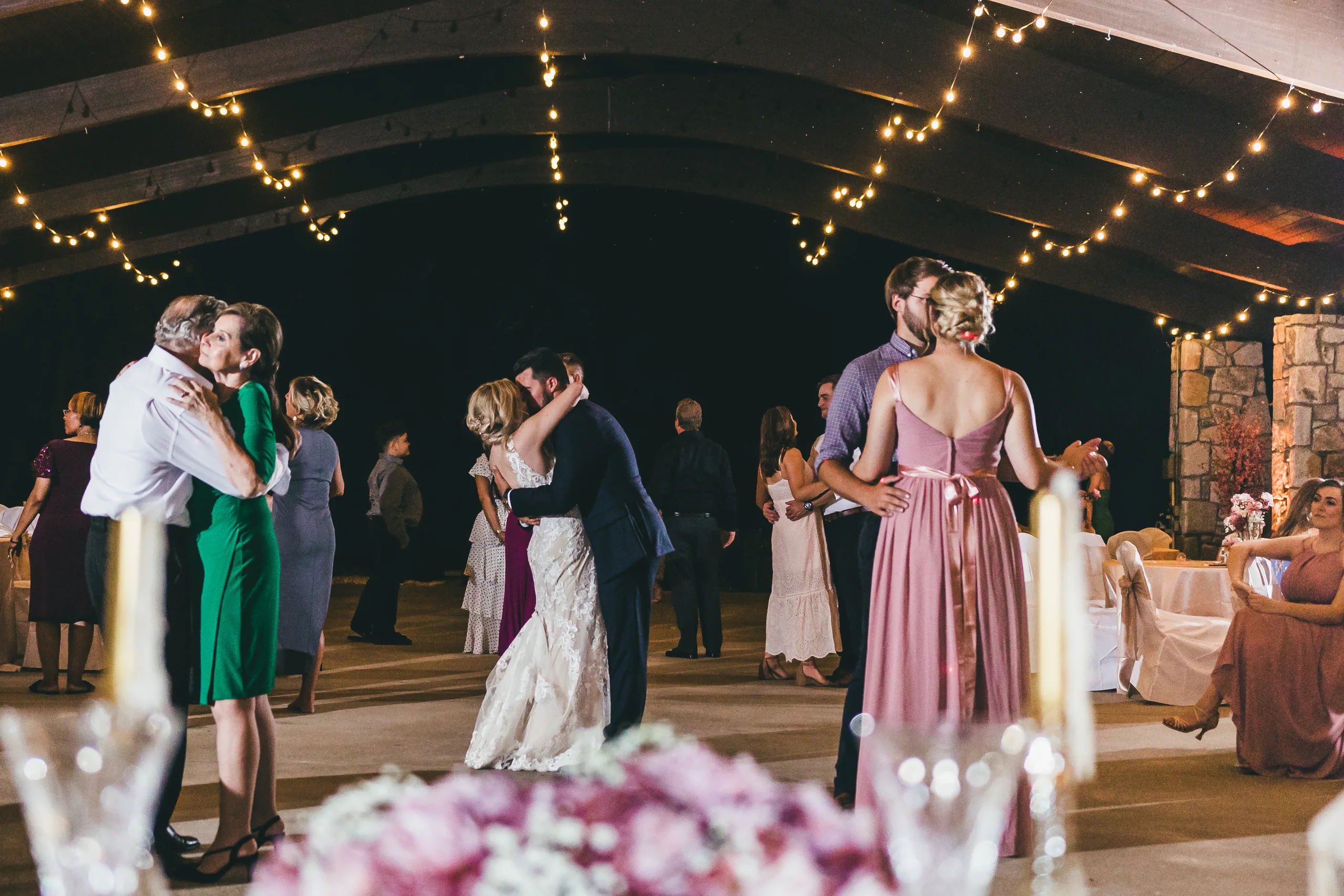 Reception: couples slow dancing under the string lights, at their wedding at Atlanta Evergreen Lakeside Resort in Stone Mountain, GA