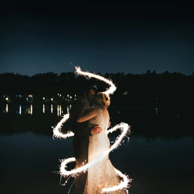 Wedding Formals: a sparkler spiral around them by the lake at night, at their wedding at Atlanta Evergreen Lakeside Resort in Stone Mountain, GA