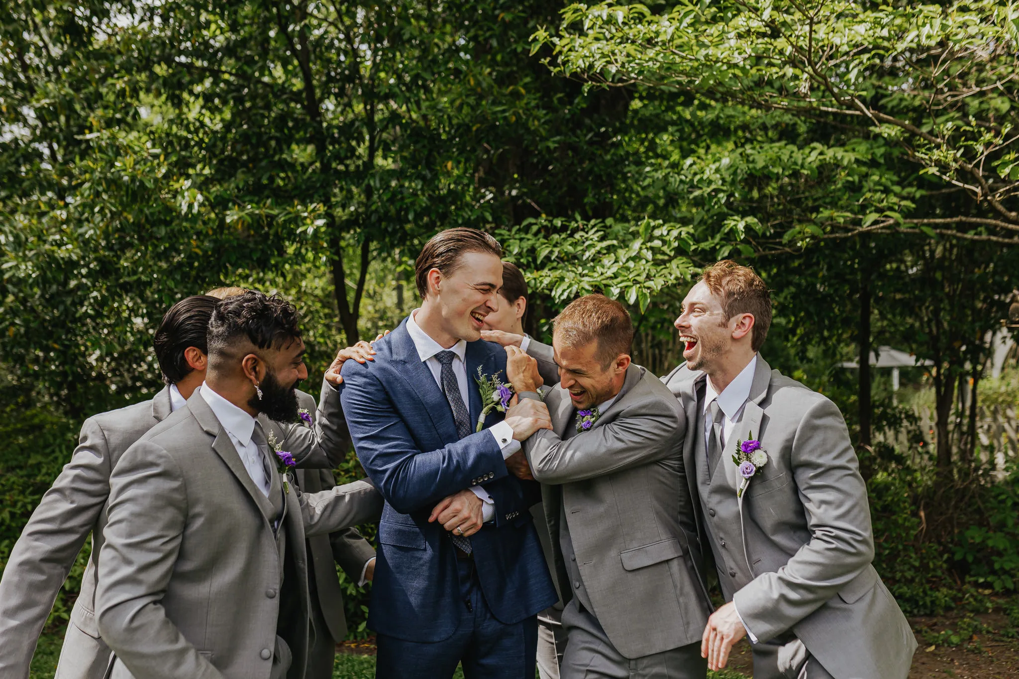 Wedding Party: the groom laughing with his groomsmen, at their wedding at The Wildflower 301 in Greensboro, GA