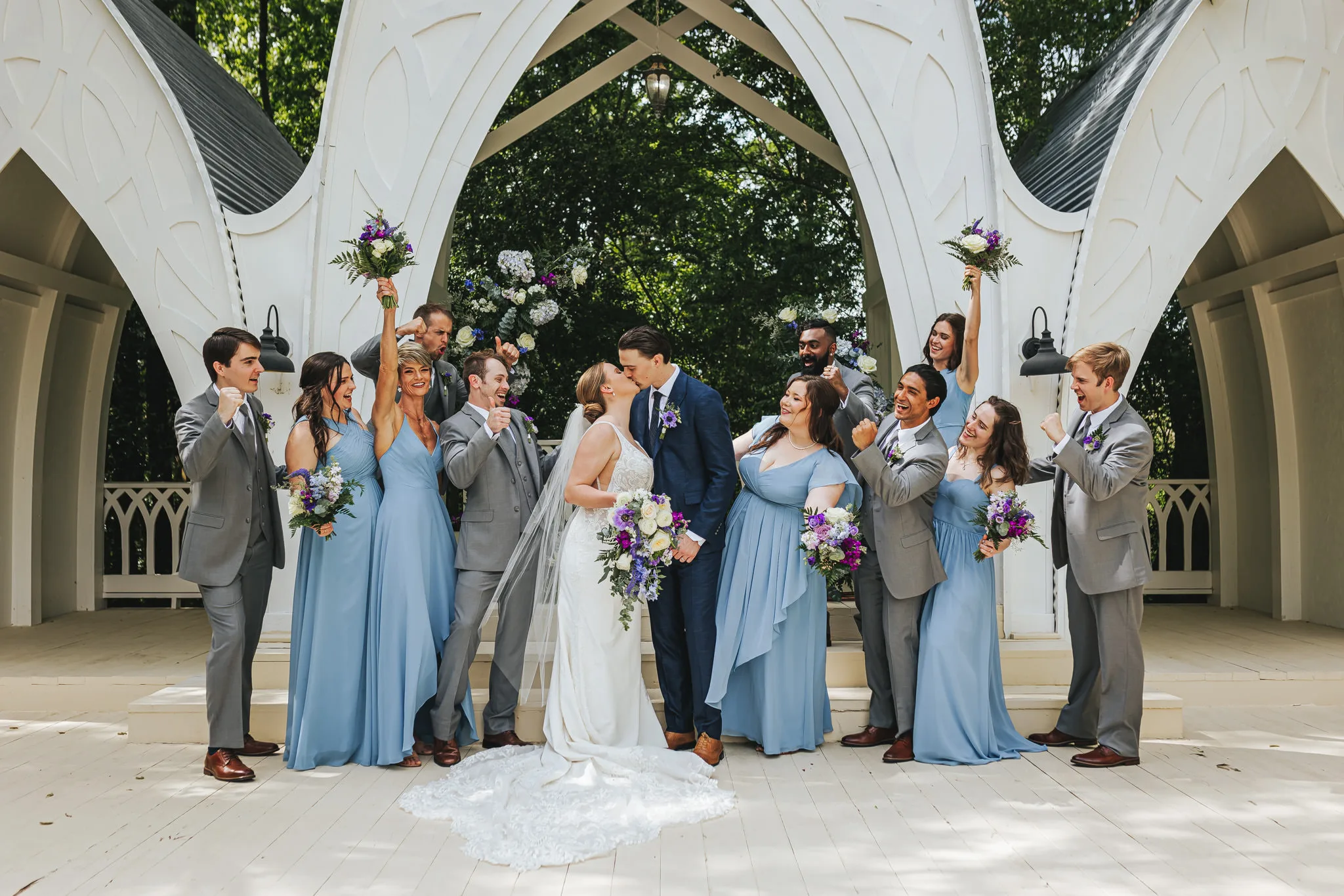 Wedding Party: the wedding party cheering under the chapel arches, at their wedding at The Wildflower 301 in Greensboro, GA