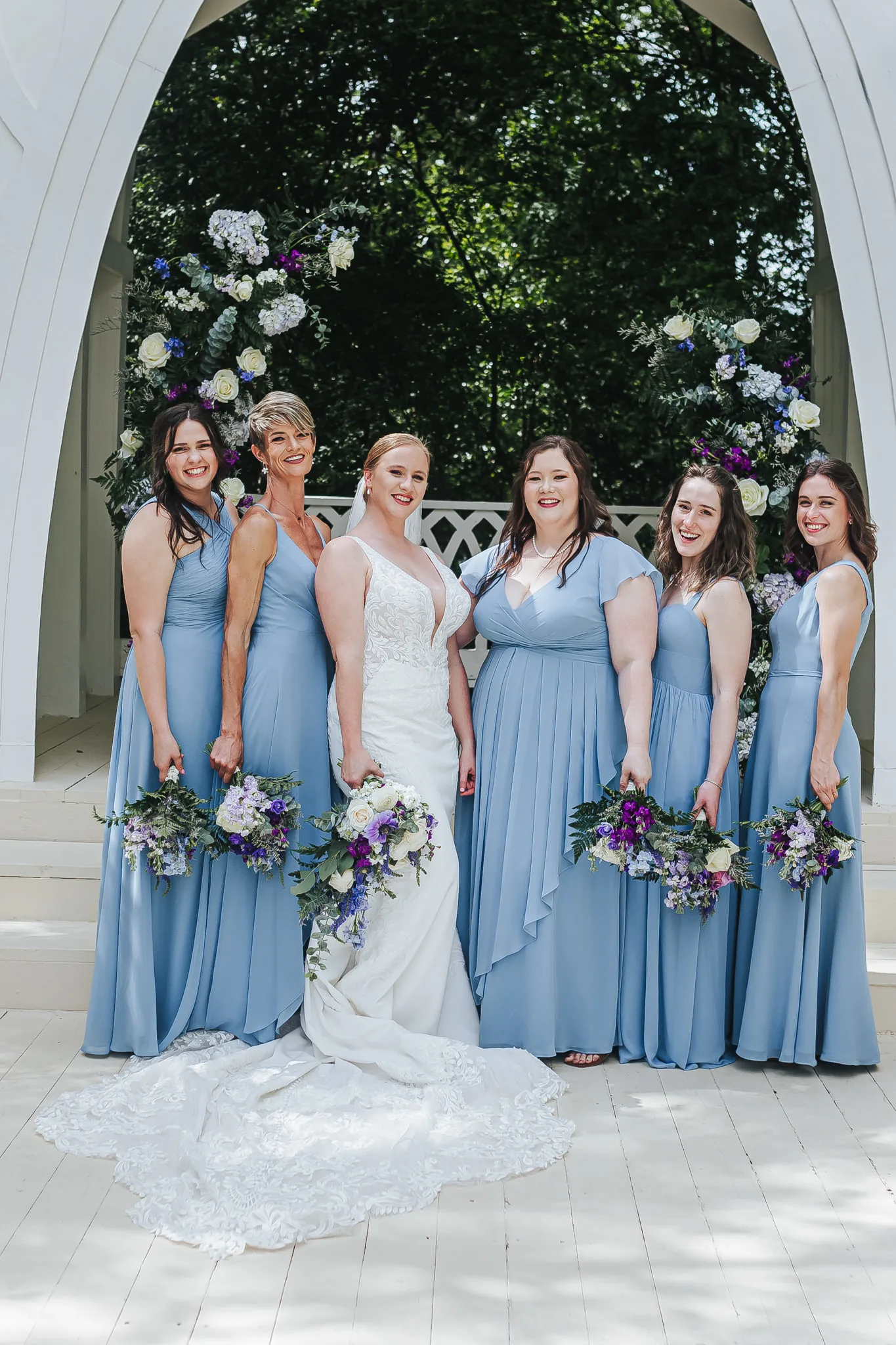 Wedding Party: the bride with her bridesmaids in dusty blue at the chapel, at their wedding at The Wildflower 301 in Greensboro, GA